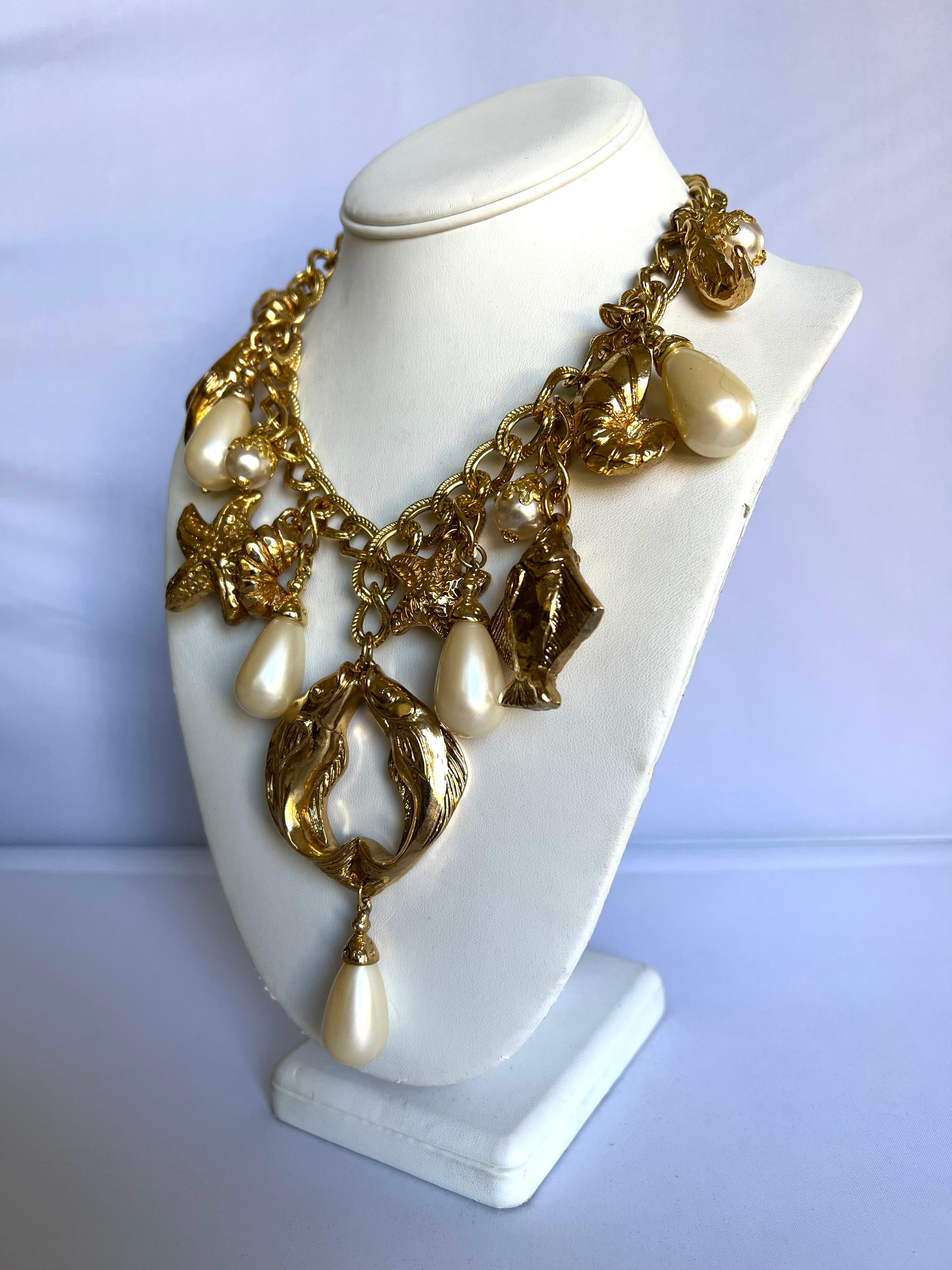 Vintage French nautical charm necklace, comprised out of a thick gilt metal chain adorned by a plethora of fish, seashells, and pearls circa 1980 by Chantal de Kerouartz. The necklace is also featured in the August issue of Vogue Spain.