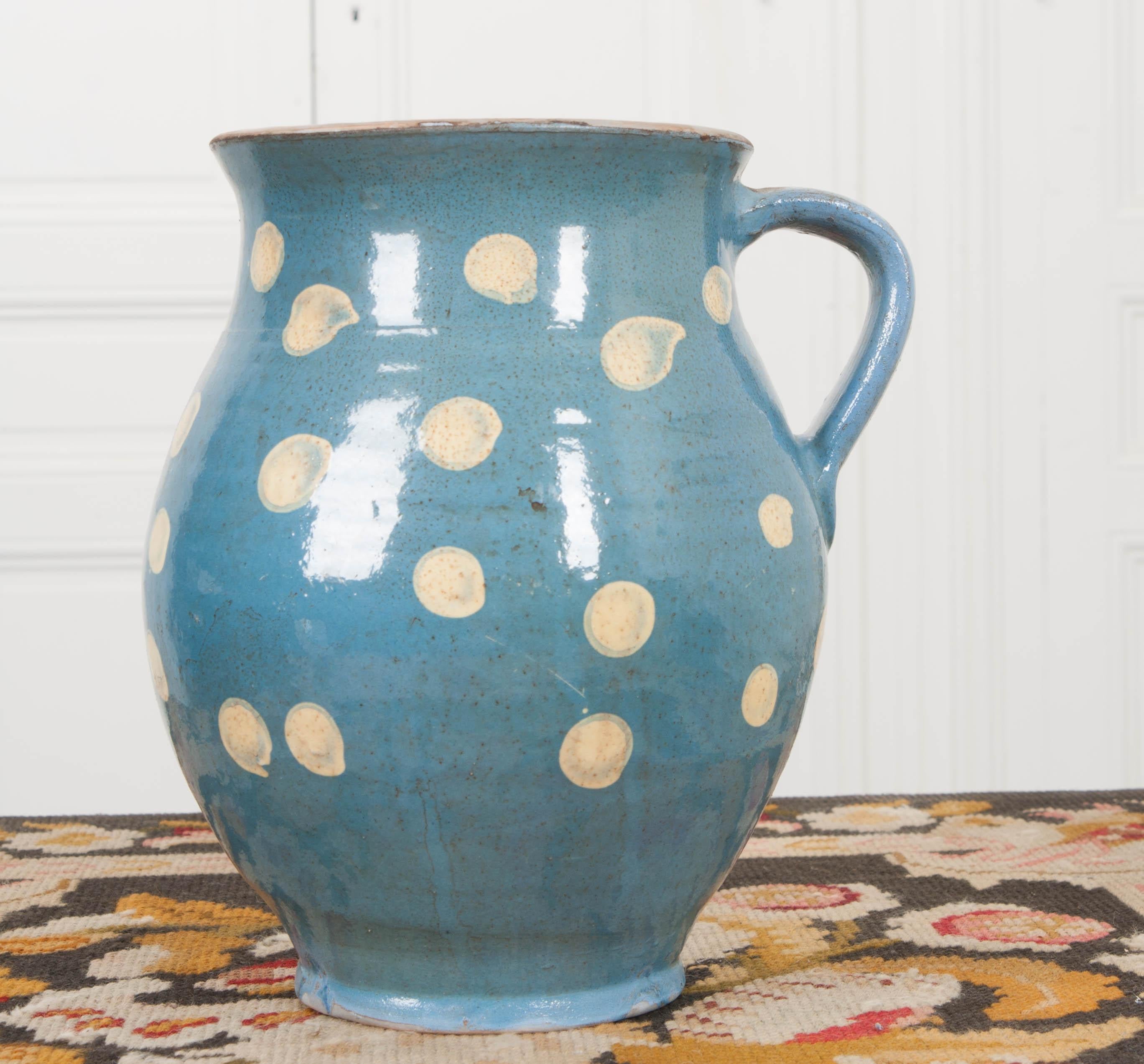 This charming French vintage glazed terra cotta pitcher has been glazed in a fantastic steel-blue, with buttermilk-colored polka-dots providing a fun and colorful design. It was handmade and hand painted, making it a sweet work of art!