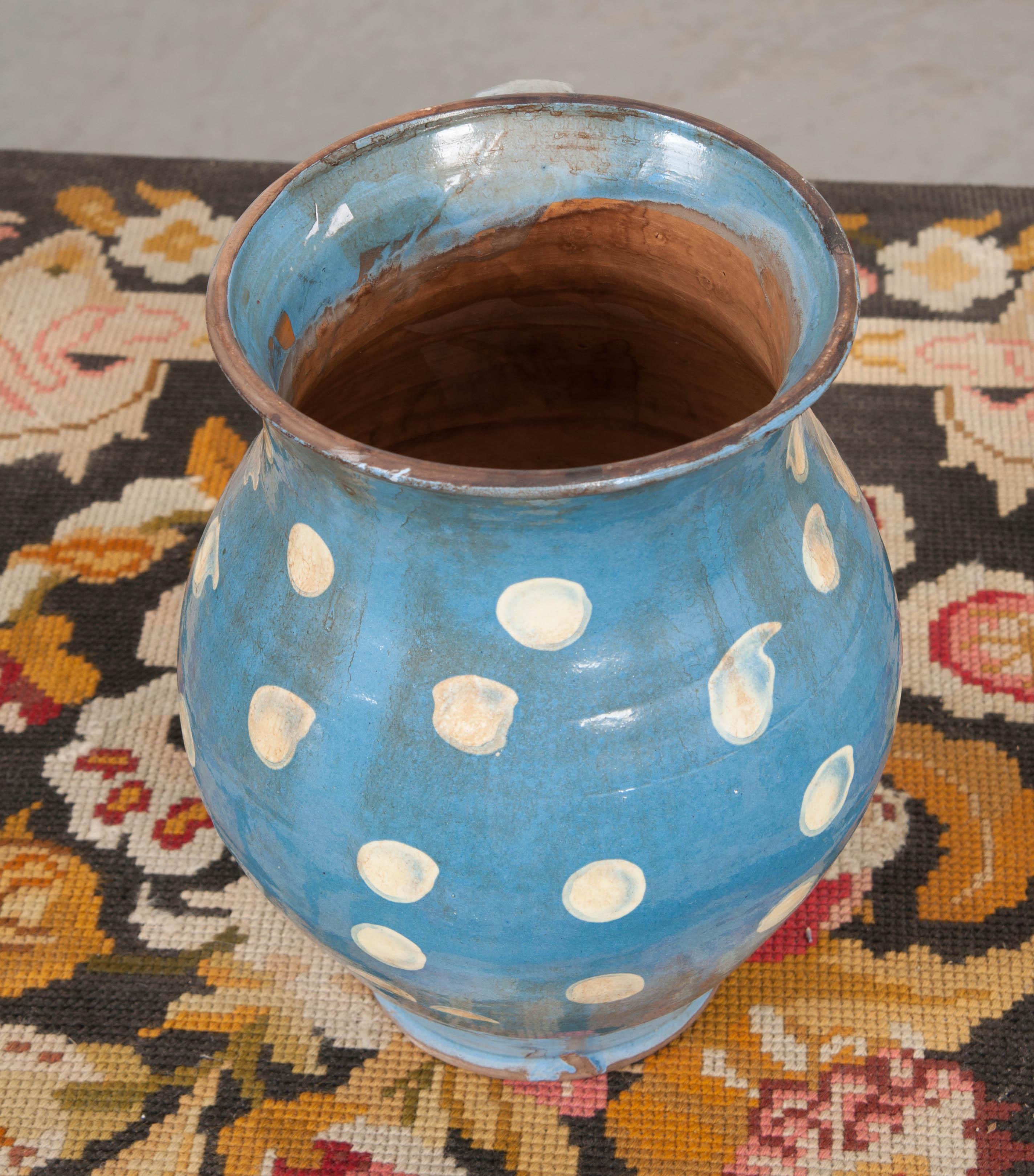 This charming French vintage glazed terracotta pitcher has been glazed in a fantastic steel-blue, with buttermilk-colored polka-dots providing a fun and colorful design. It was handmade and hand painted, making it a sweet work of art!