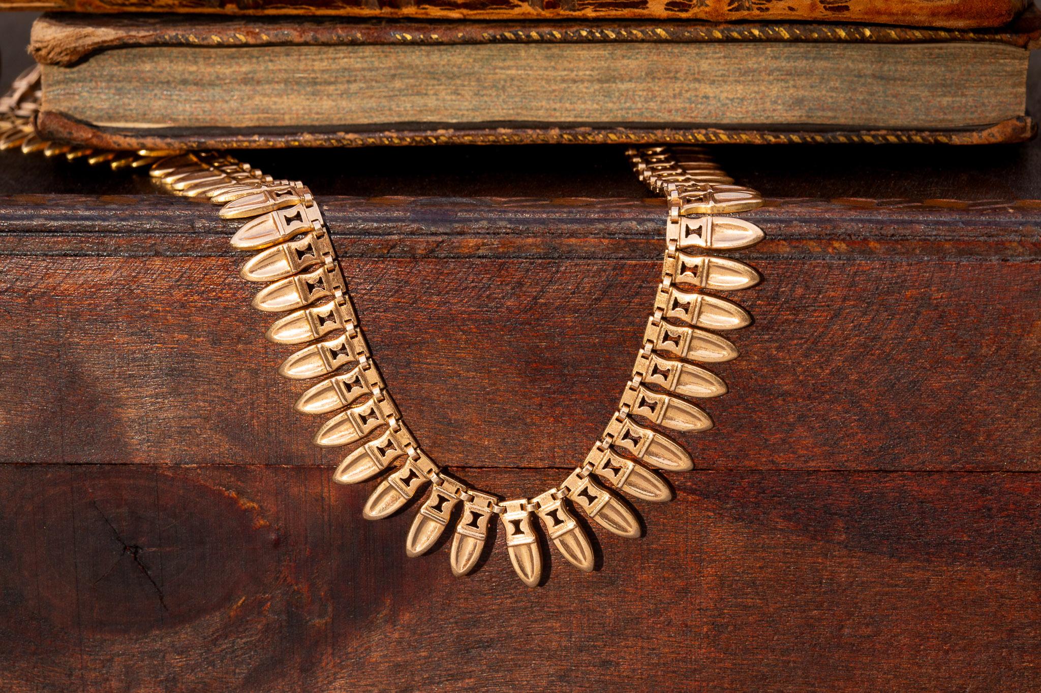 A superb gold archaeological revival fringe necklace, made in France and dating from the 1940’s.

The necklace is crafted with 30 grams of rich, rosy 18K gold and decorated with a continuous row of amphora-shaped drops. The design is inspired by the