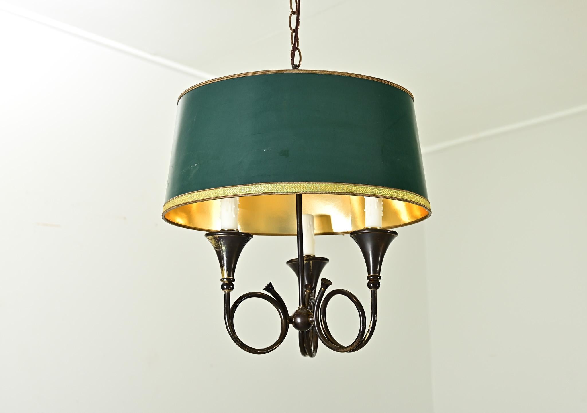 A charming vintage French horn brass chandelier from the mid-20th century, based on earlier bouillote style table lamps. Three arms shaped like miniature horn instruments terminate in flared cones to support the candle covers of the electrical