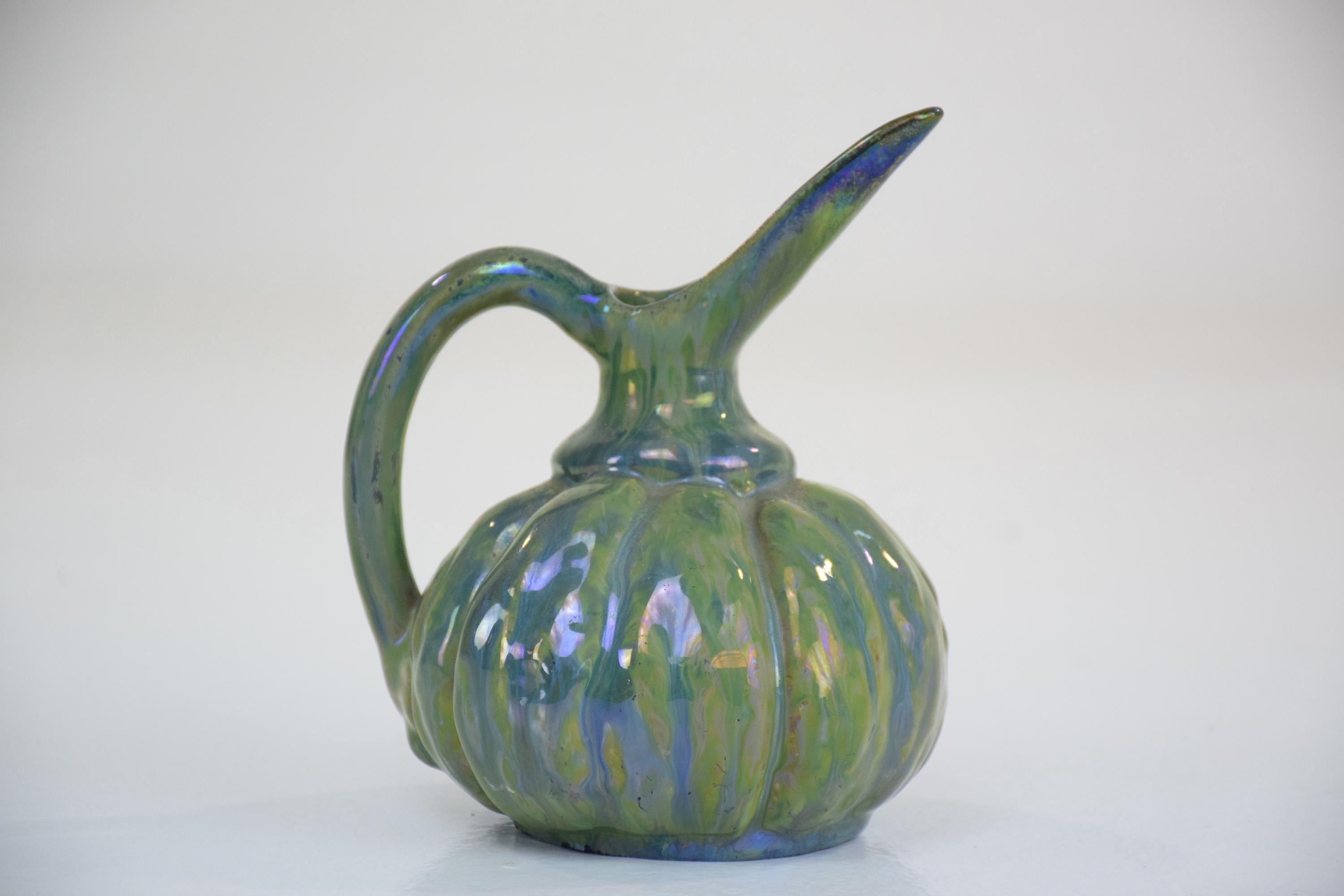 A 20th century French vintage collectible pitcher or jug of circular shape crafted in a green iridescent color,
France, 1910.
Signed at reverse Alphonse Cytère, a notable ceramist who invented the metallic effect on ceramic. 

1903 Alphonse