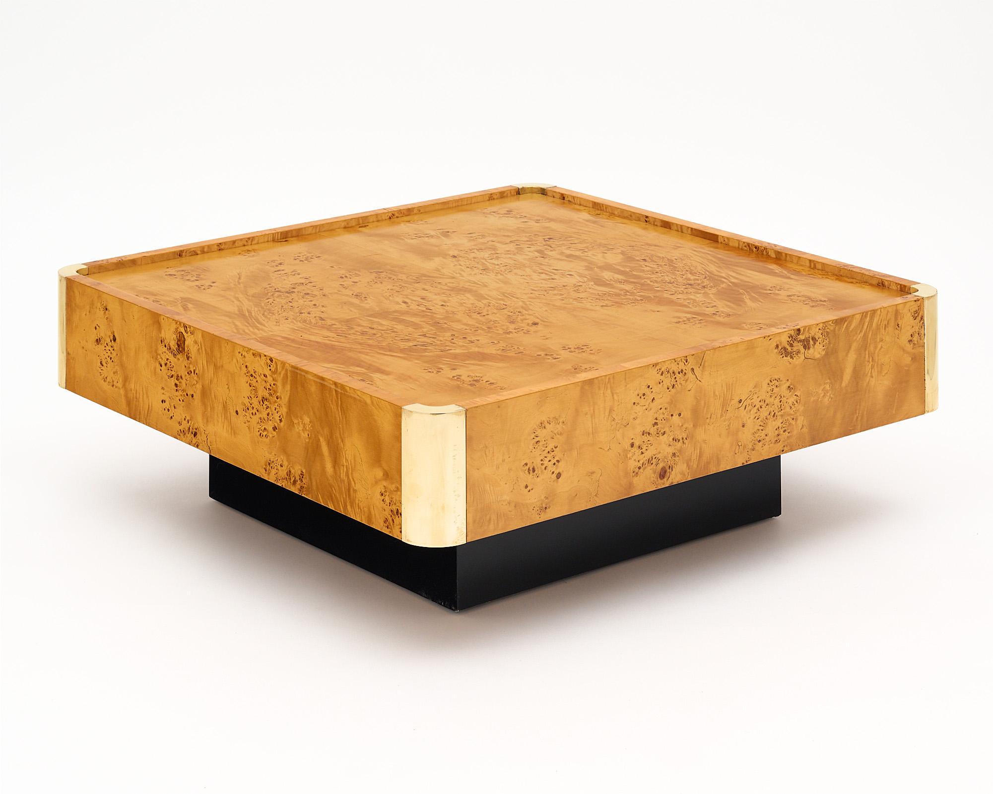 Vintage coffee table from France designed by Jean-Claude Mahey. This piece has a burled ash veneer and each curved corner is capped in brass. The top insets for added functionality. The base has been ebonized and the whole piece is finished with a