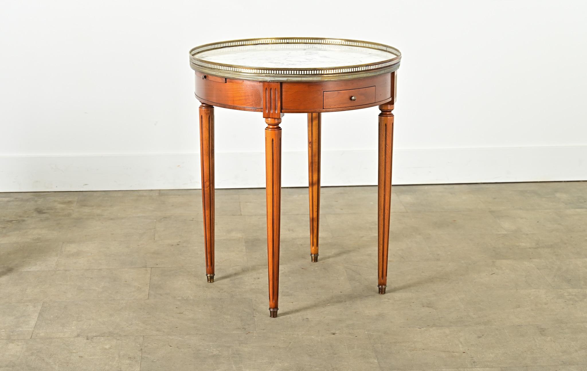 Mesa auxiliar francesa de caoba, estilo Luis XVI, de mediados del siglo XX, con tablero de mármol blanco rodeado de una galería de latón calado y elevada por patas acanaladas. Este diseño de mesa atemporal es un ejemplo clásico de forma y función,