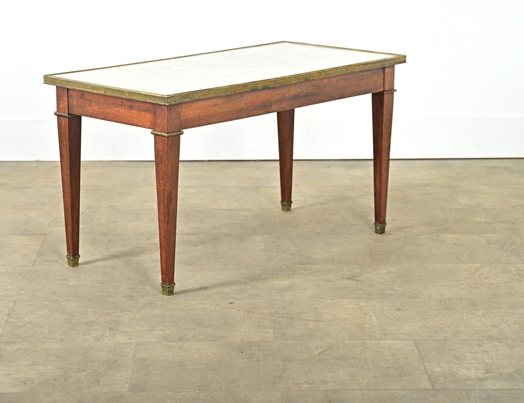 Französischer Vintage-Mahagoni-Couchtisch (Anfang 20. Jh.) im Louis-XVI-Stil, der für den modernen Geschmack verfeinert wurde und sich problemlos in Interieurs von Directoire bis Art Déco einfügt. Eine schlichte Messingzierleiste umgibt die