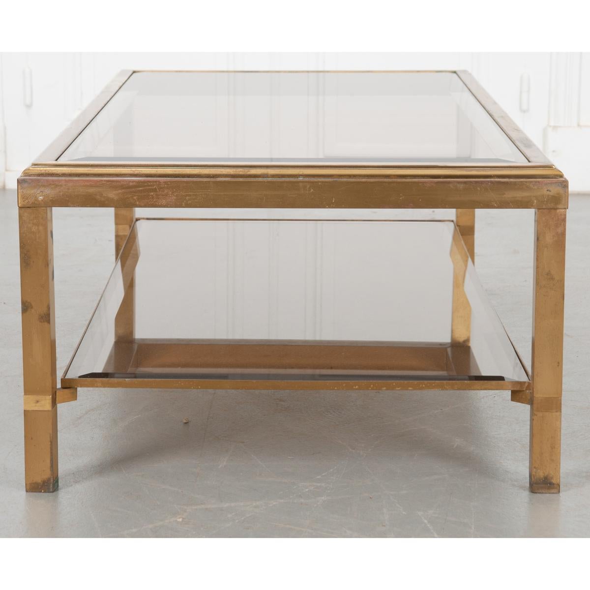 This is a great vintage cocktail table that because of its height works as a coffee table. Top and bottom pieces of tinted glass are beveled providing the perfect surface to display your favorite decor. Both pieces are supported in a rectangular