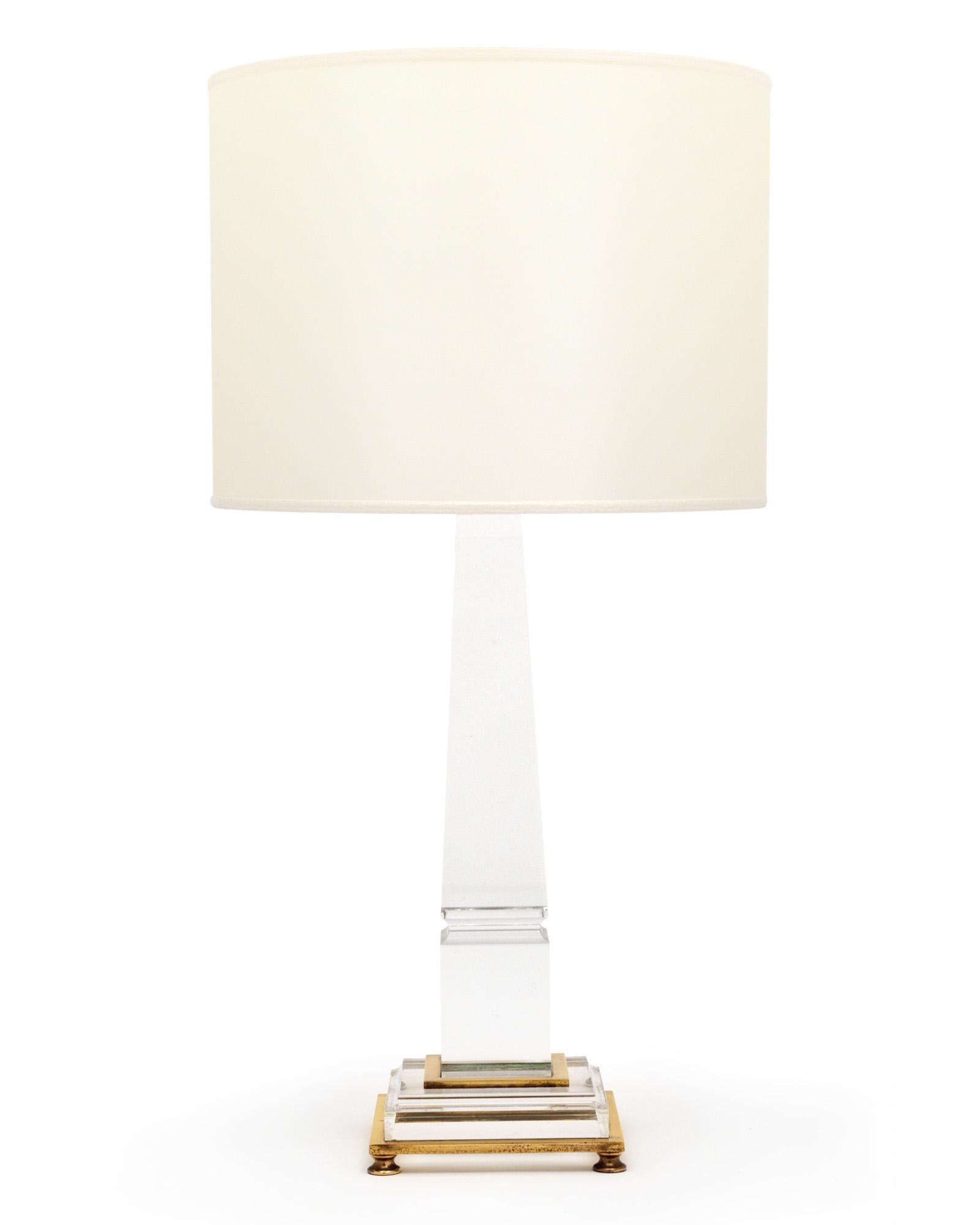 Lámpara individual de la Francia de mediados de siglo. Esta pieza está hecha de Lucite transparente con adornos de latón alrededor de la parte inferior y patas de latón como soporte. Las lámparas están en muy buen estado vintage y se han cableado de