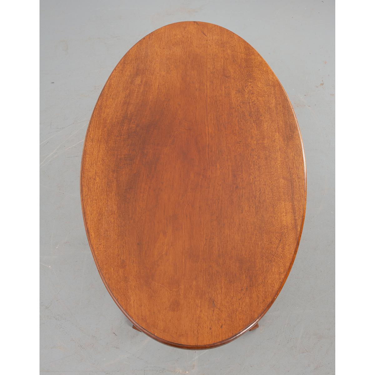 Il s'agit d'une belle table basse française vintage. Le bois est de l'acajou et est formé en un bel ovale avec un piédestal et quatre jambes ou pieds qui se déplient. Idéal pour les endroits où l'espace est limité.