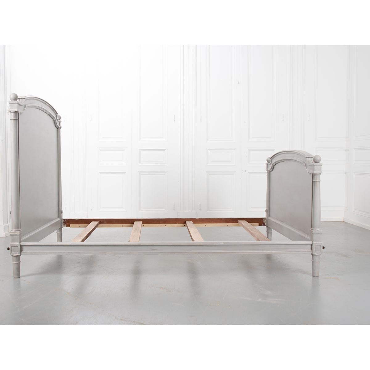 This elegant, French vintage bed was recently painted in a soft grey. It has a slight arch across the headboard and the footboard with columns on the corners. The width is good for a queen, but the rails would need to be extended if you wanted to