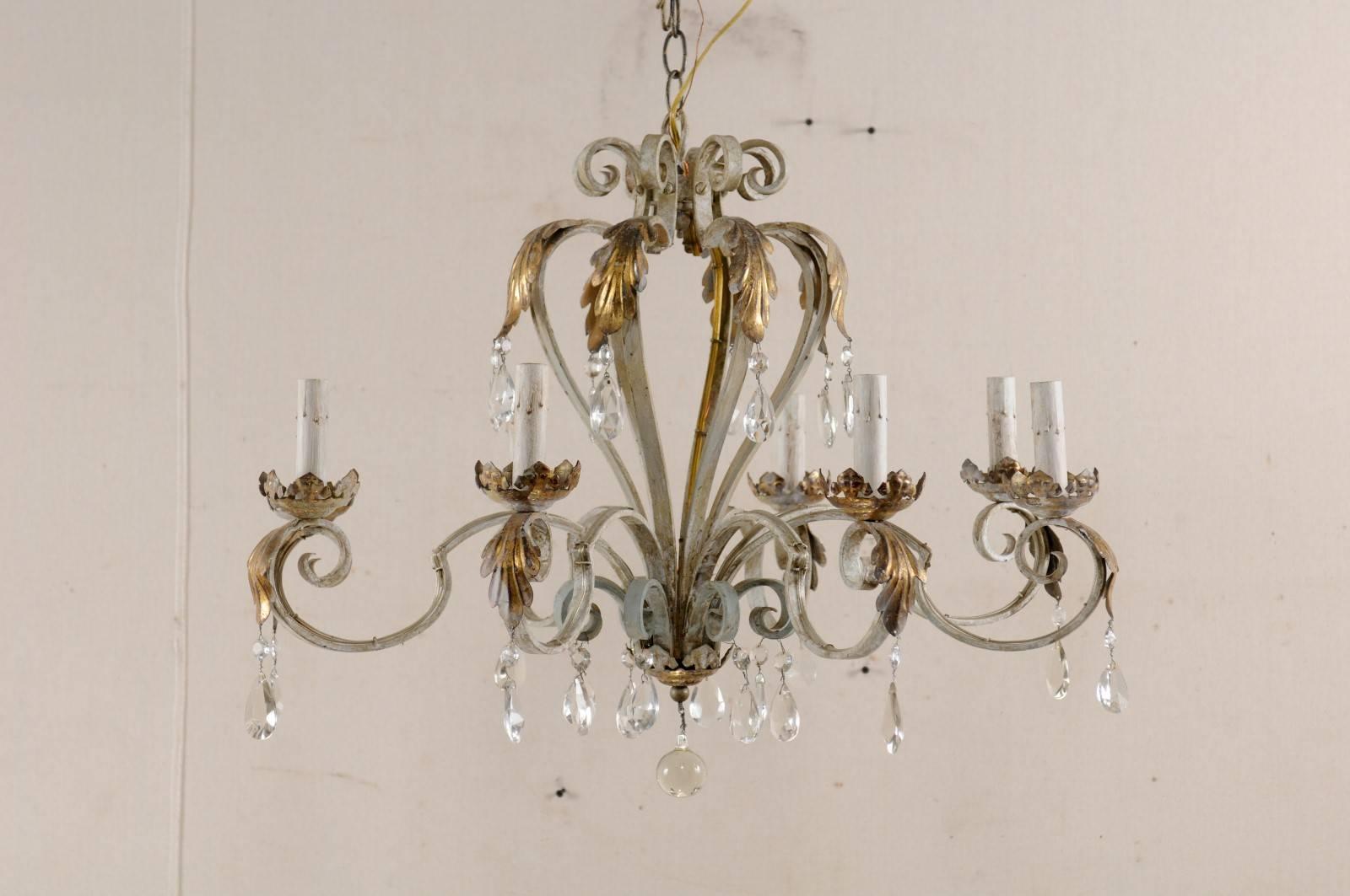 A French vintage eight-light painted iron and crystal chandelier. This French iron chandelier from the mid-20th century features scrolling armature, adorned in an acanthus leaf motif, decorated with hanging crystals, and glass ball bottom finial.