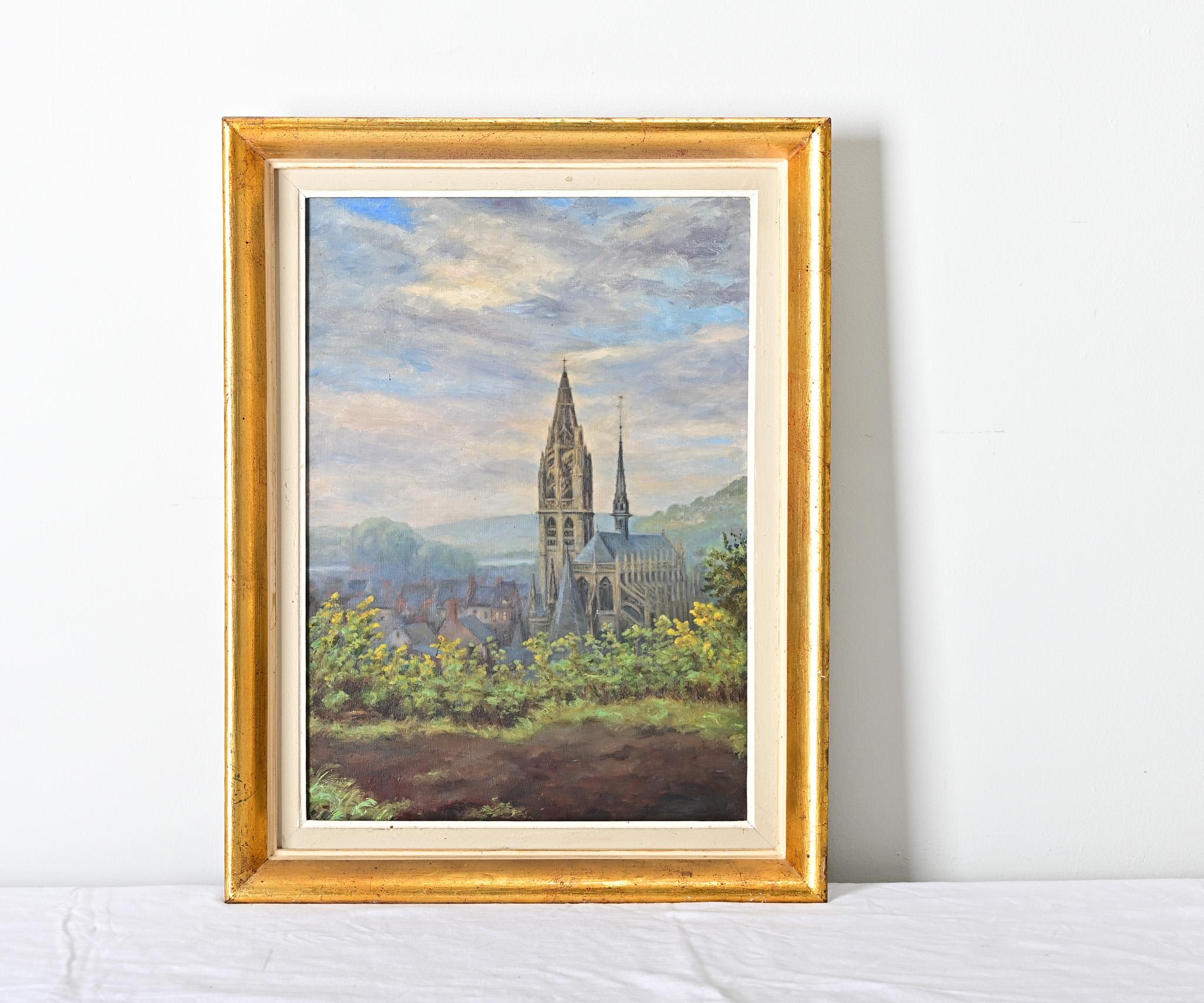 Quadro paesaggistico d'epoca francese incorniciato a olio su tela raffigurante una cattedrale gotica che sovrasta il suo pittoresco villaggio. In lontananza si possono osservare colline lussureggianti e ondulate sotto nuvole vaporose di lavanda e a