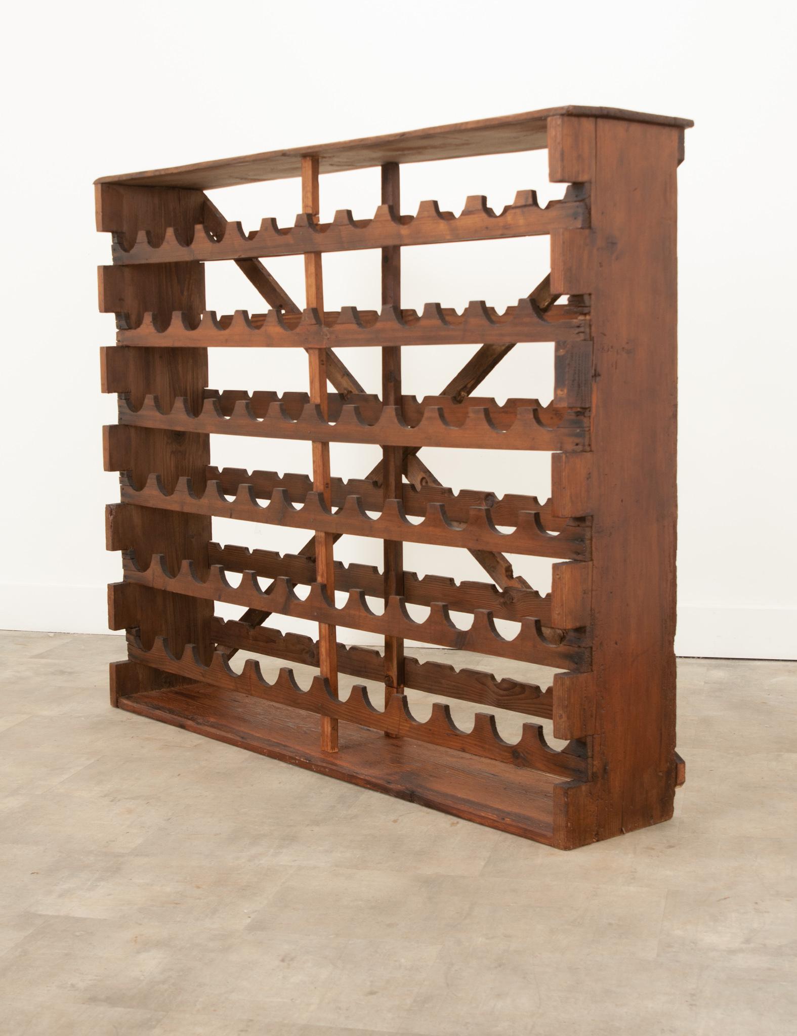 A well made vintage French standing wine bottle storage rack made of beautiful pine. A gorgeous hand-carved piece with a highly functional design that is perfect for storing and displaying wine bottles horizontally in order to preserve the cork. The