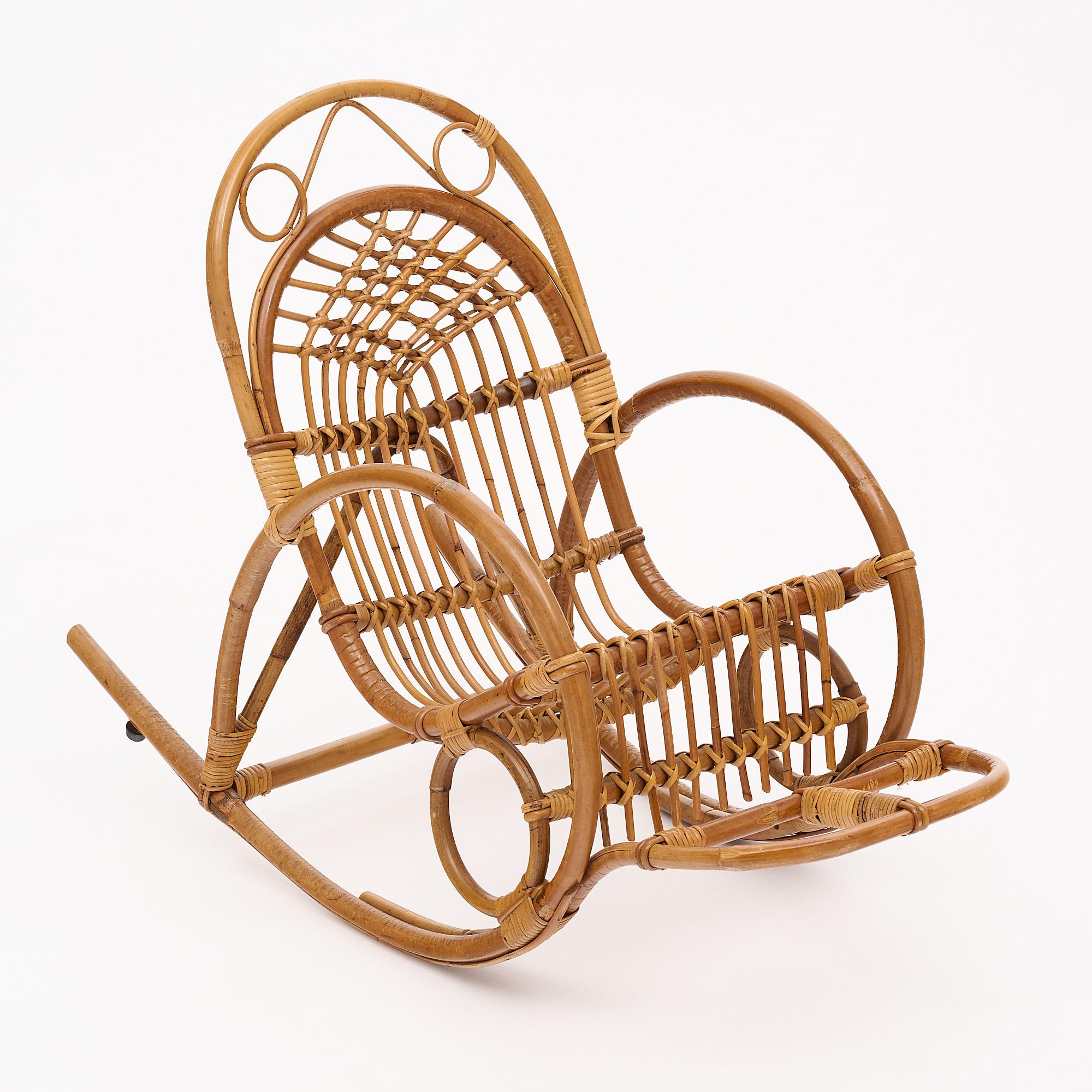 Rattan child’s rocking chair. From the region of Lyon, France. This chic little chair features a foot rest.