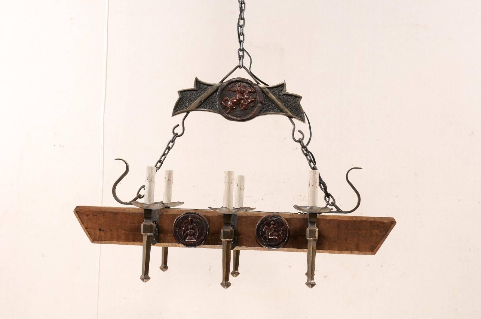 A French vintage, rectangular-shaped, forged-iron and wood beam six-light chandelier. This French mid-20th century chandelier features a central horizontal wood beam with six torch style iron arms, three projecting out along each side, of which