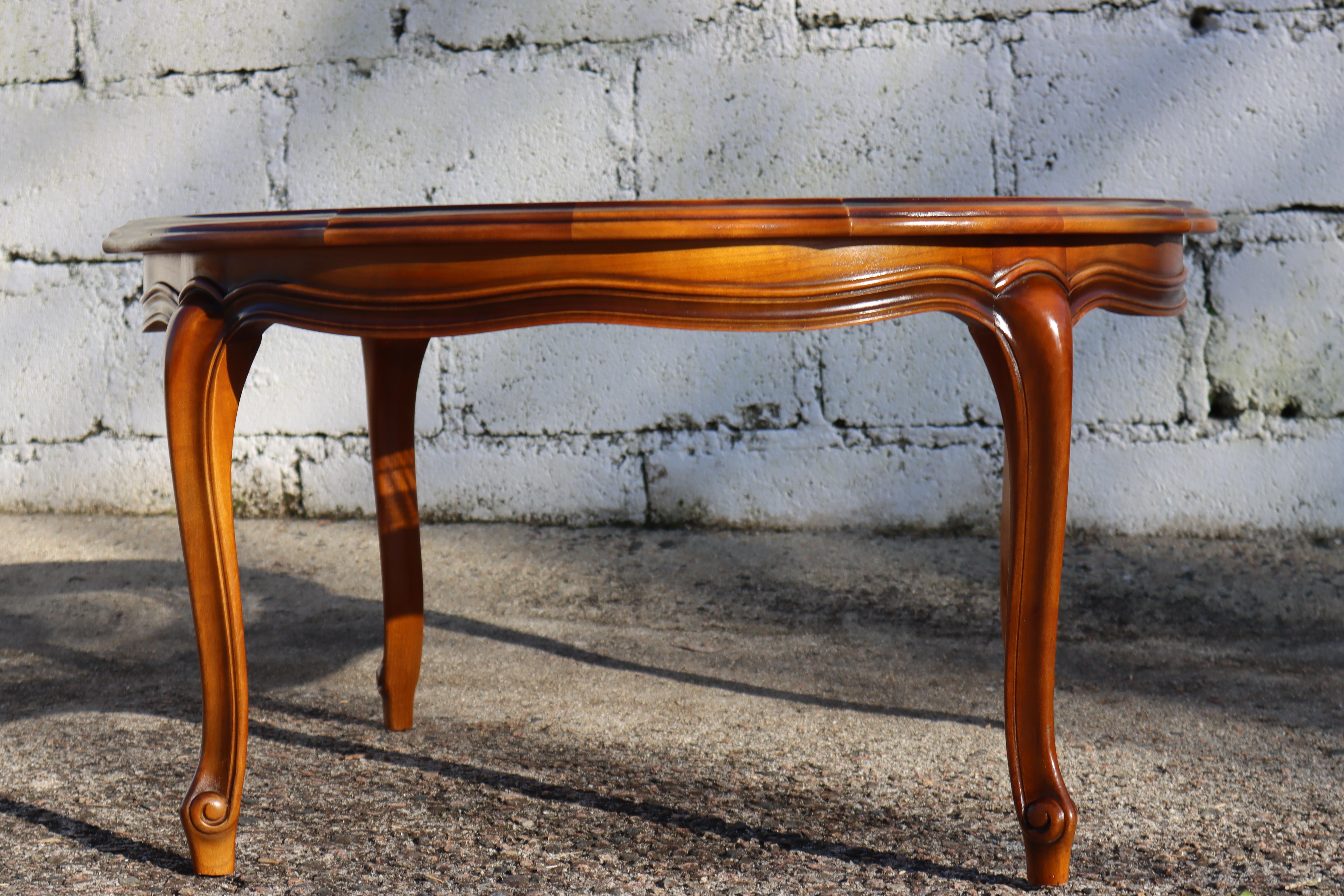 Big authentic round Cane Glass Coffee Table - Cocktail Table  from the 60s
Made of Cherry Wood, richly decorated with Wood Carvings-beautifully curved CabrioleLegs
The table has a Glass Insert, underneath an artistic Cane Wickerwork.

A beautiful