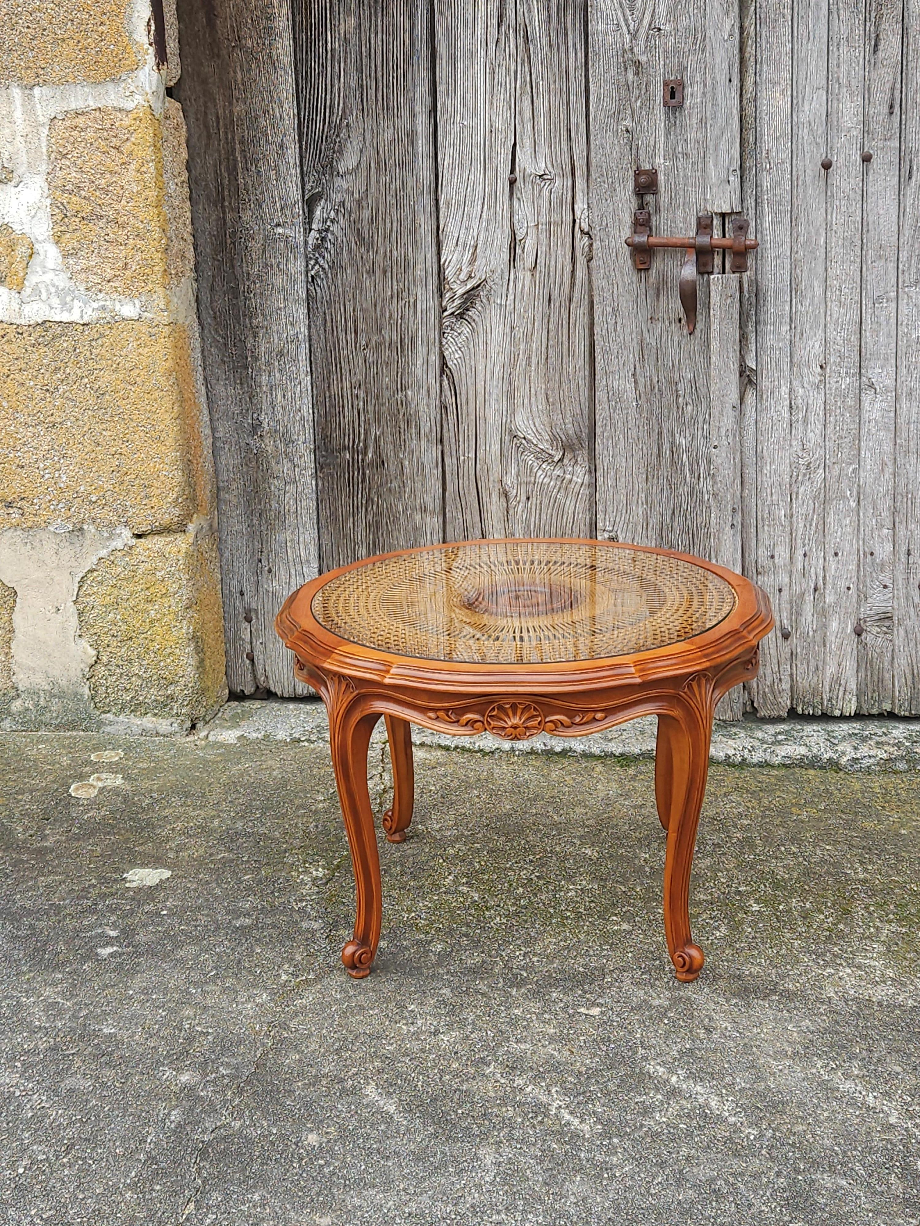 Beautiful and Authentic French round Coffee Table from the 60s
Made of Cherry Wood, richly decorated with Wood Carvings and beautifully curved Cabriole Legs
The Table has a Glass Insert, underneath an artistic Cane Wickerwork.
It has a Sunburst
