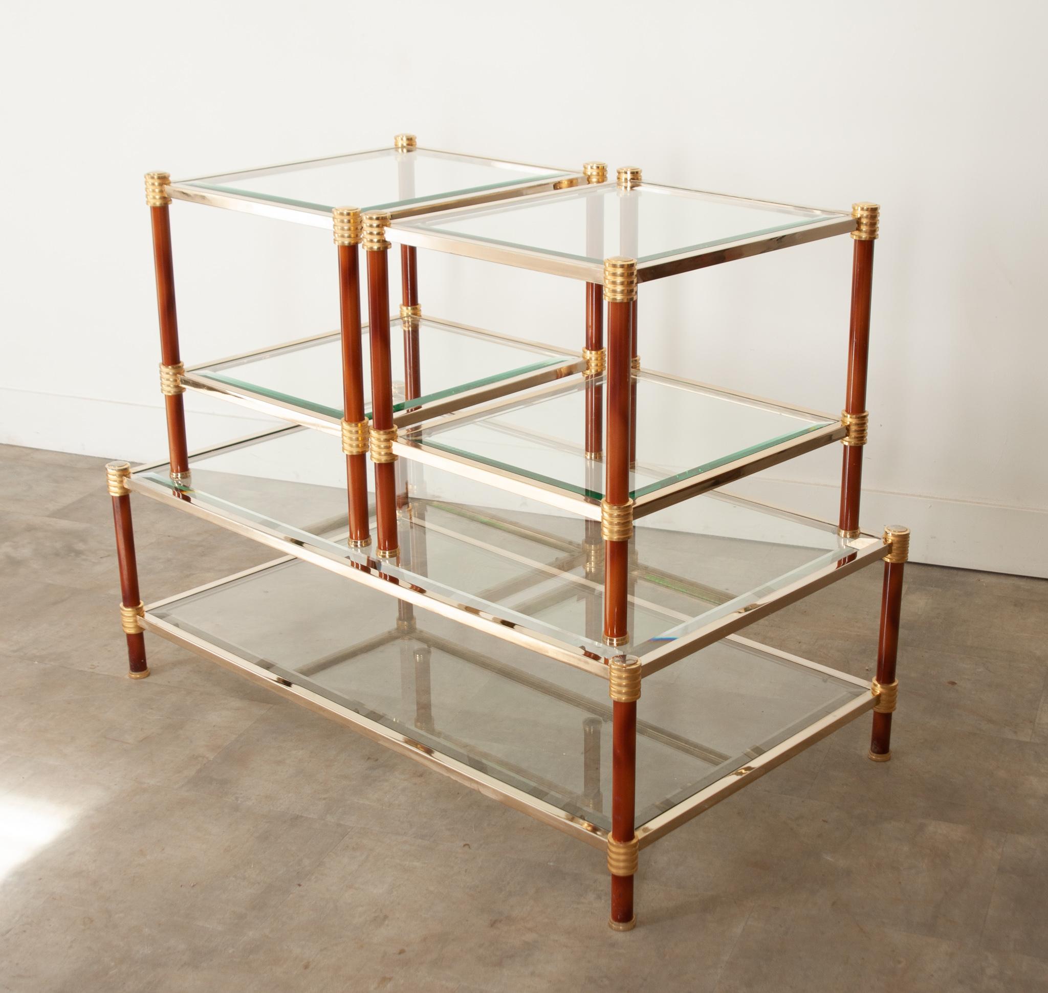 A fabulous vintage set of French brass and glass coffee and side tables with unique flair. Their frames are made of brass and supported by metal faux finished cylindrical legs with decorative brass caps. Snuggly enclosed in brass, the glass top