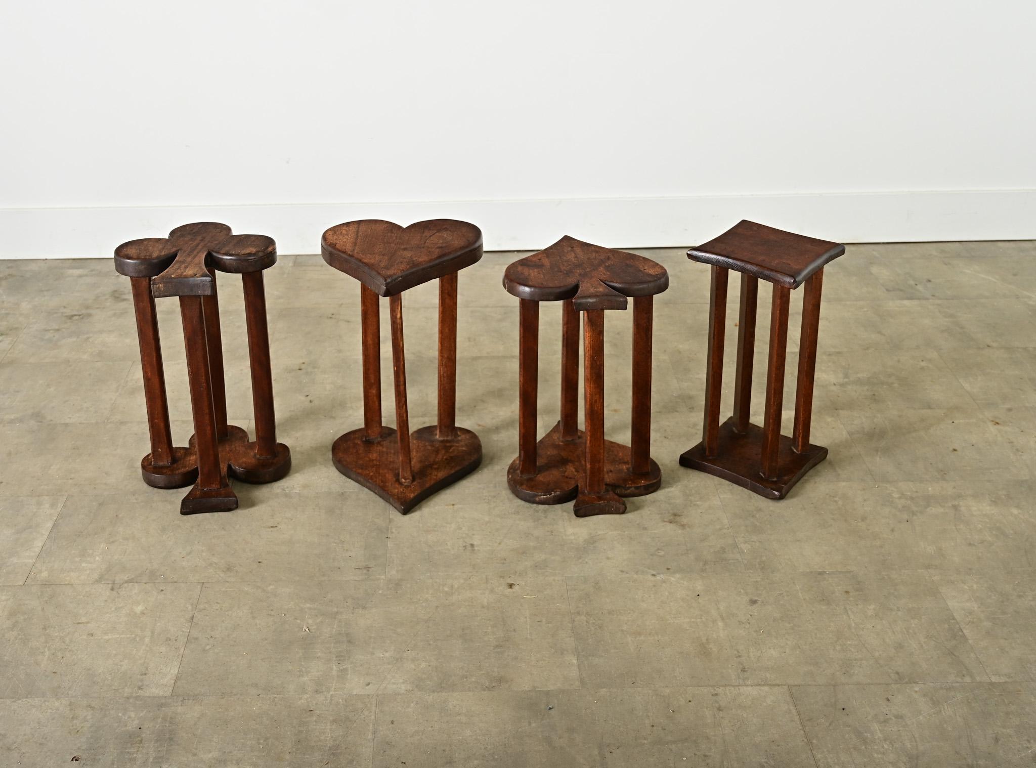 A very unique set of four French vintage (early 20th century) occasional tables or stools, carved from oak in the familiar shapes of each playing card suit: a club, a diamond, a heart, and a spade. Their simplified, reversible design is light and