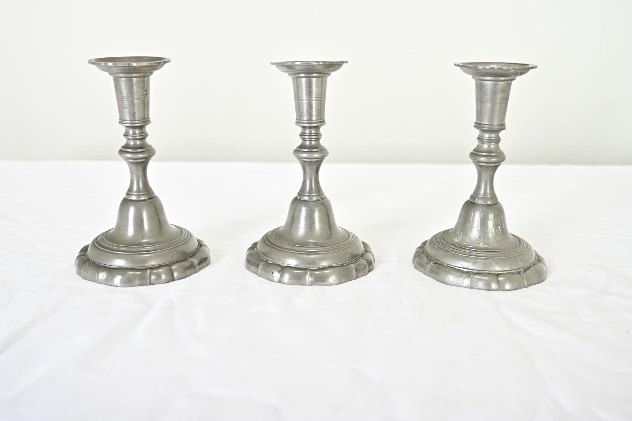 Chandeliers vintage en étain du 20e siècle provenant de France, reflétant les goûts Louis XV et rococo. Les chandeliers présentent une silhouette fascinante sur la colonne qui se rétrécit et se gonfle gracieusement jusqu'à s'évaser à la base avec