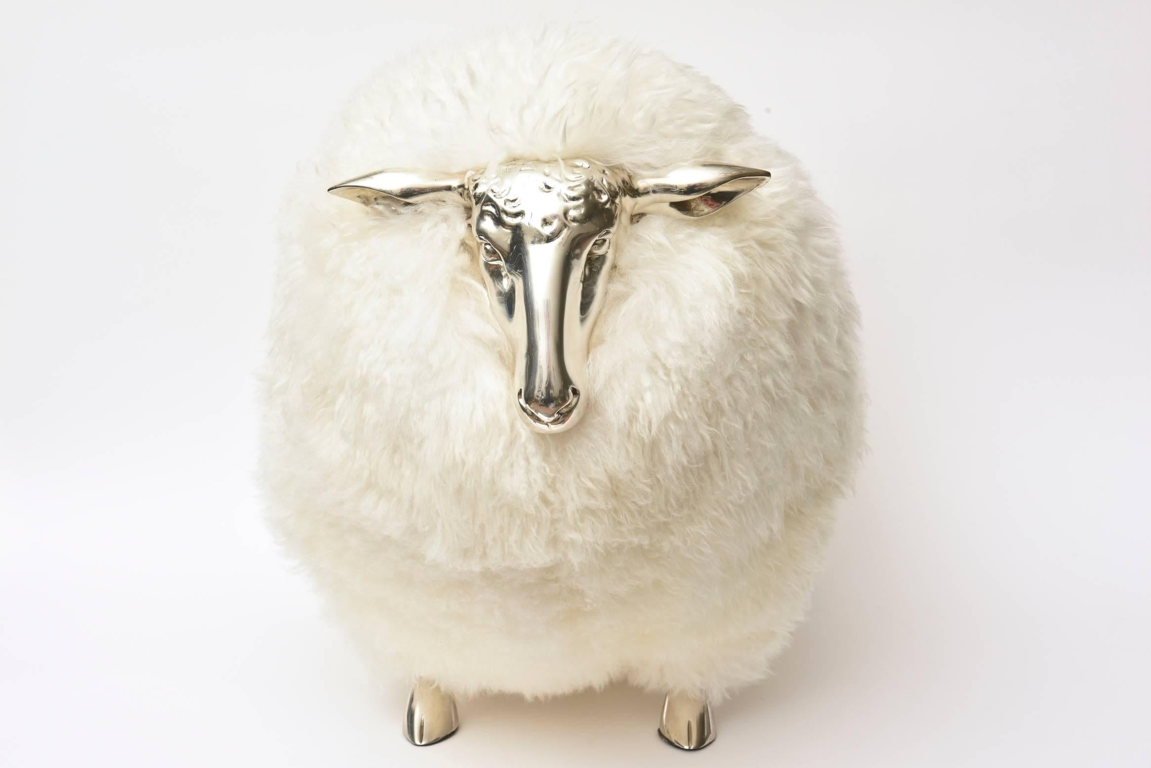 This sculptural French sheep bench or ottoman is off-white shearling and nickel silver as the face and hoof legs. This is called new old stock. It was made then and placed in a warehouse in France and not seen again until recently. This particular