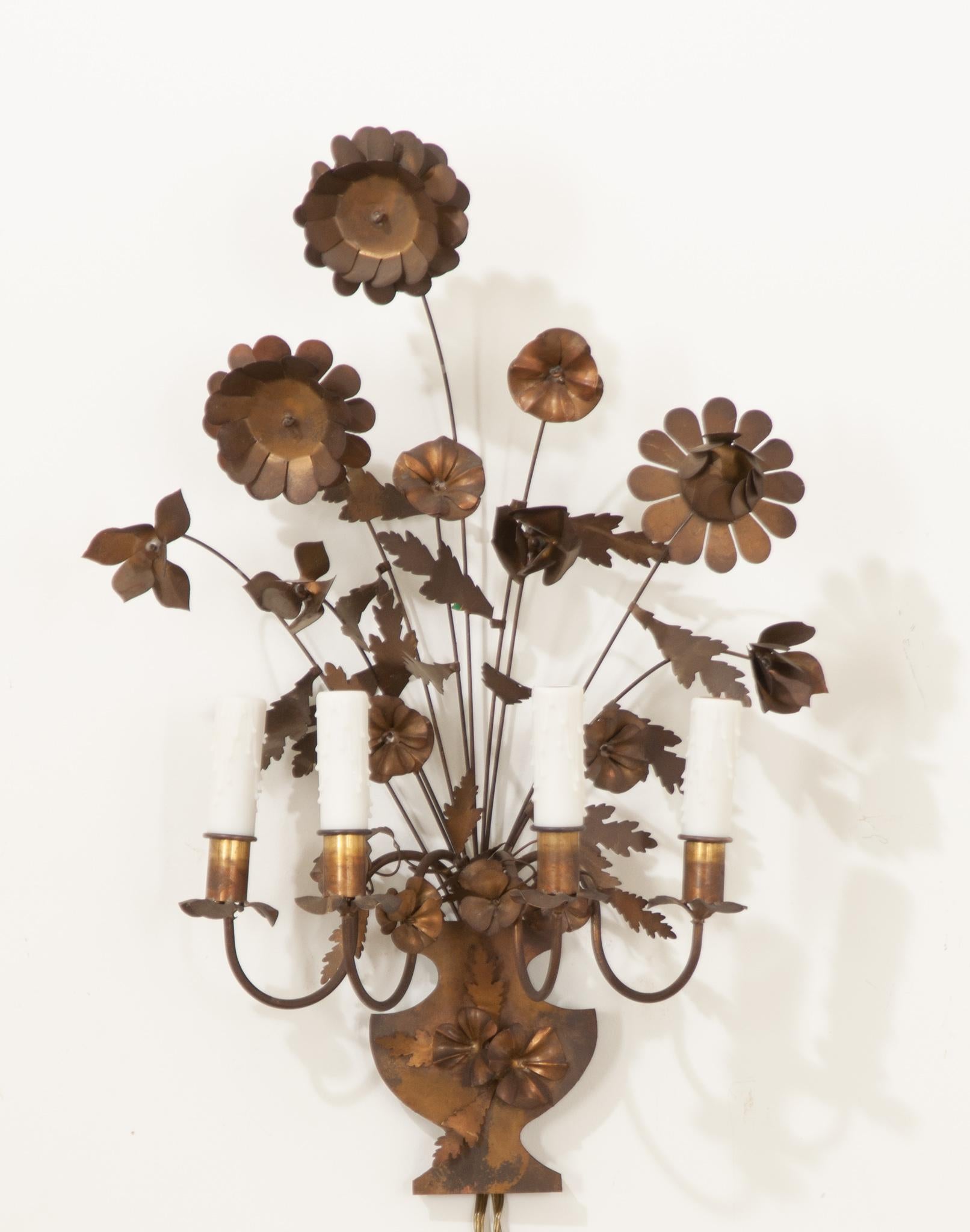 This whimsical vintage French sconce is the perfect way to add an organic element to your space. Crafted from thin brass and formed into flowers, the lightweight medium allows for some movement of the tall stems. This single sconce features four