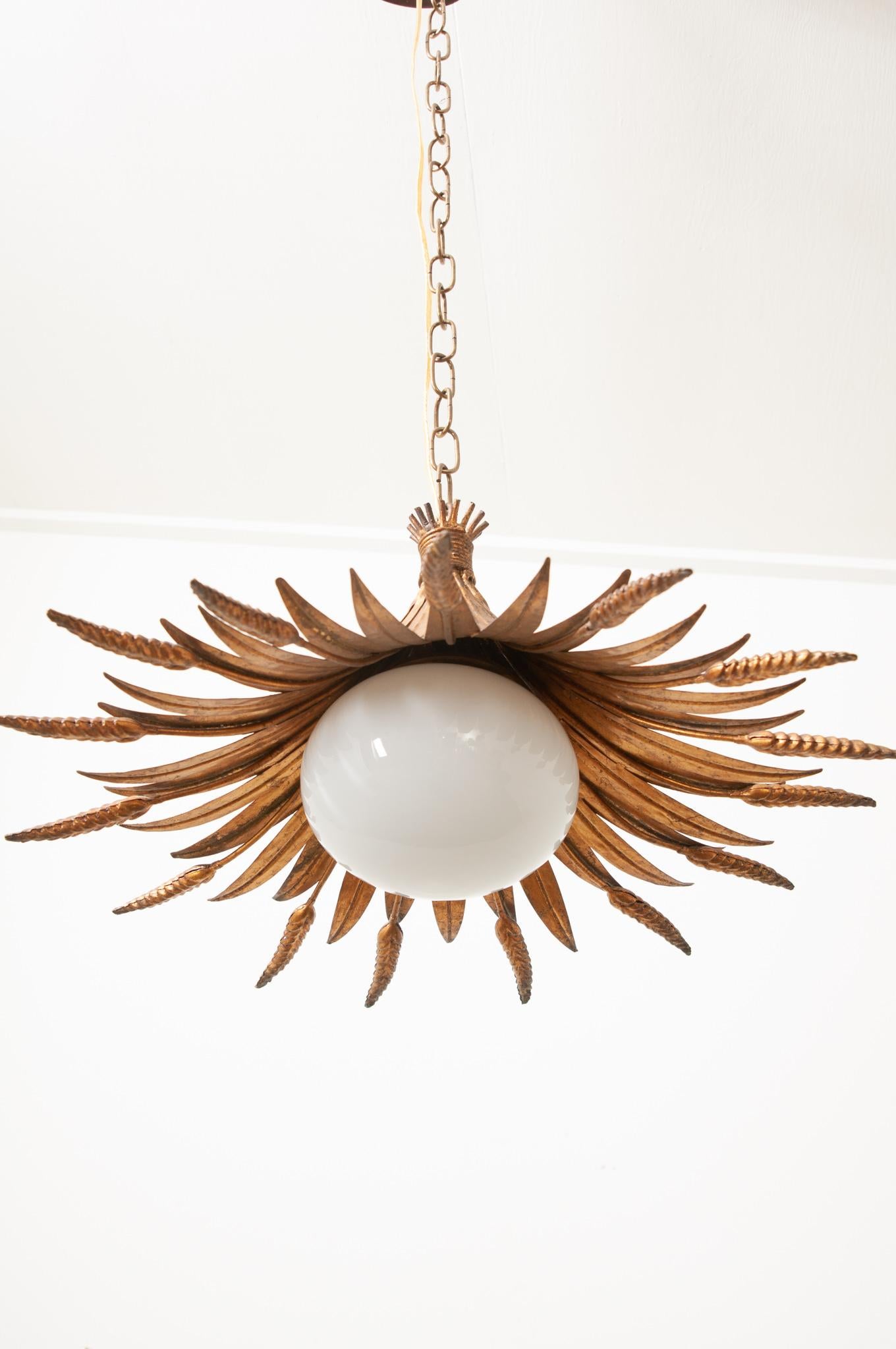 A playful vintage pendant from France is made of a brass wheat bouquet with a single bulb. The bulb is surrounded by a removable milk glass globe. This is the perfect light to give your interior a bit of whimsy. The single pendant comes with the