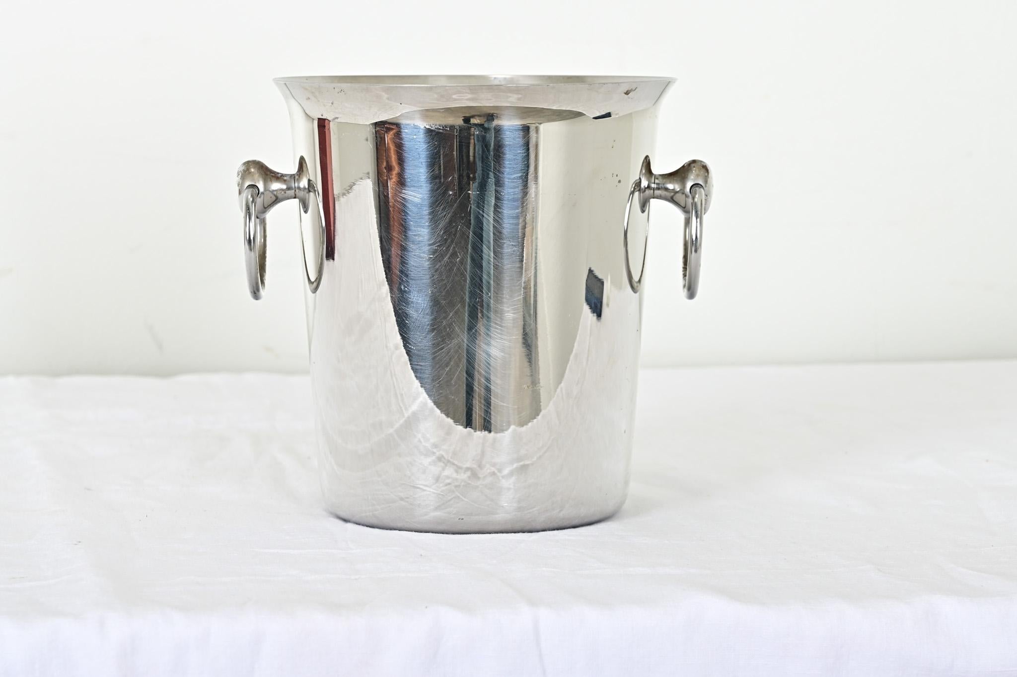 An entertaining essential for any host, this 18/10 steel champagne bucket or wine chiller from France is going to be a durable and dependable fixture at the bar. Ring handles at the sides with a horsebit shape make an elegant presentation and easy