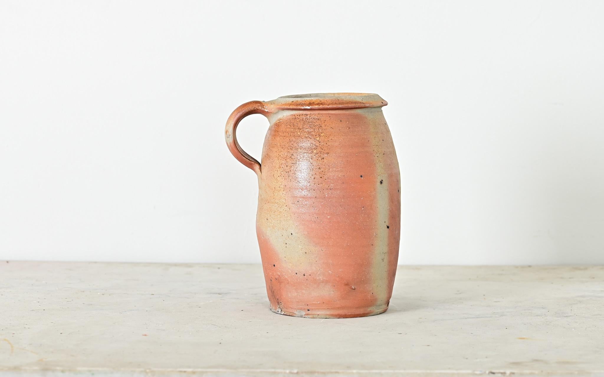 A French vintage glazed stoneware confit-type pot with handle. This utilitarian Provincial vessel would have been used to store and preserve foods (like a confit or rillette). Glazed in a ruddy blend of earthtones over the ribbed body, it becomes a