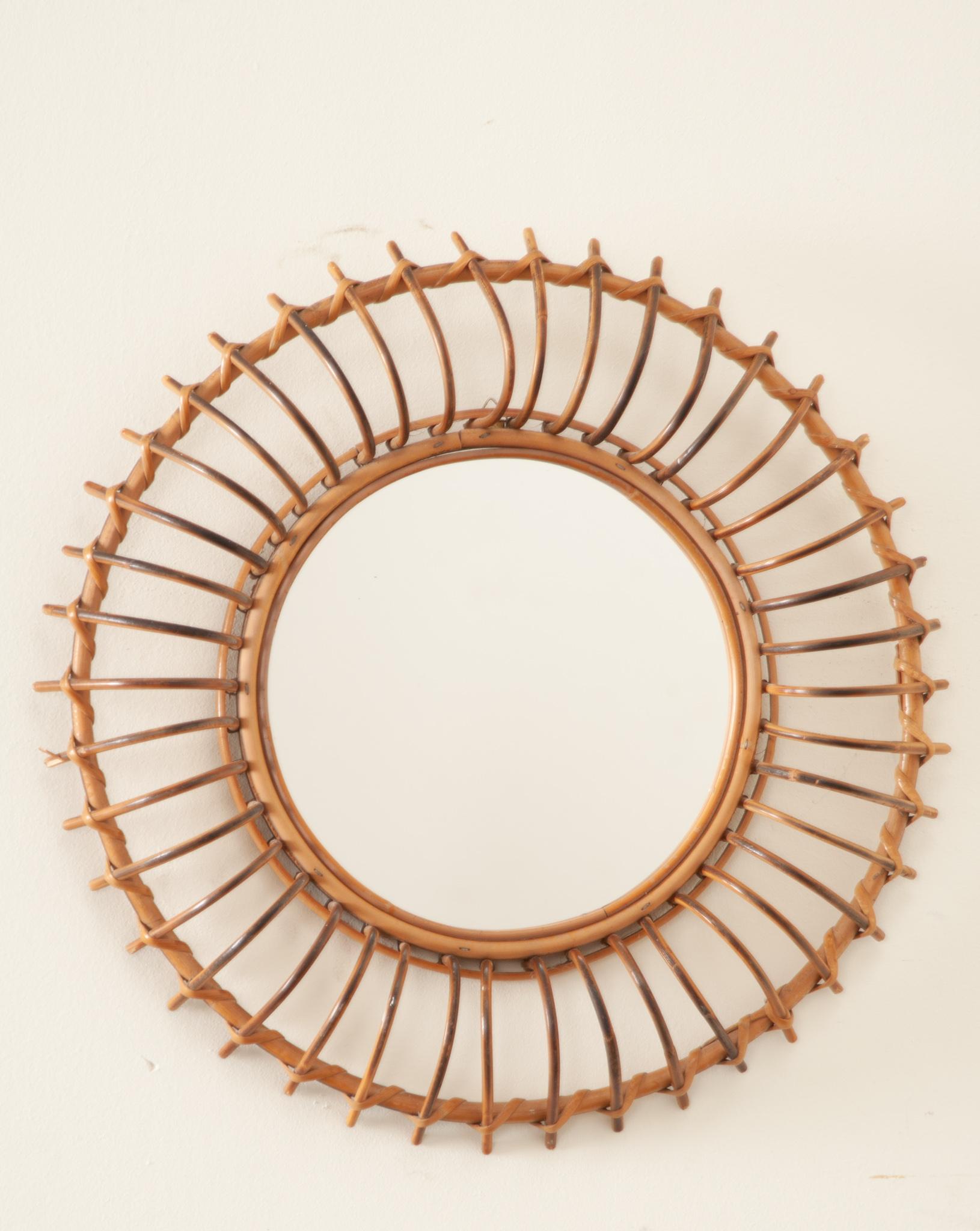 A groovy round rattan mirror from France. Eye-catching and lovely with a sunburst design on honeyed brown rattan. This handcrafted mirror would be a nice addition to a beach house, country home or urban bohemian apartment. A cool accent placed alone