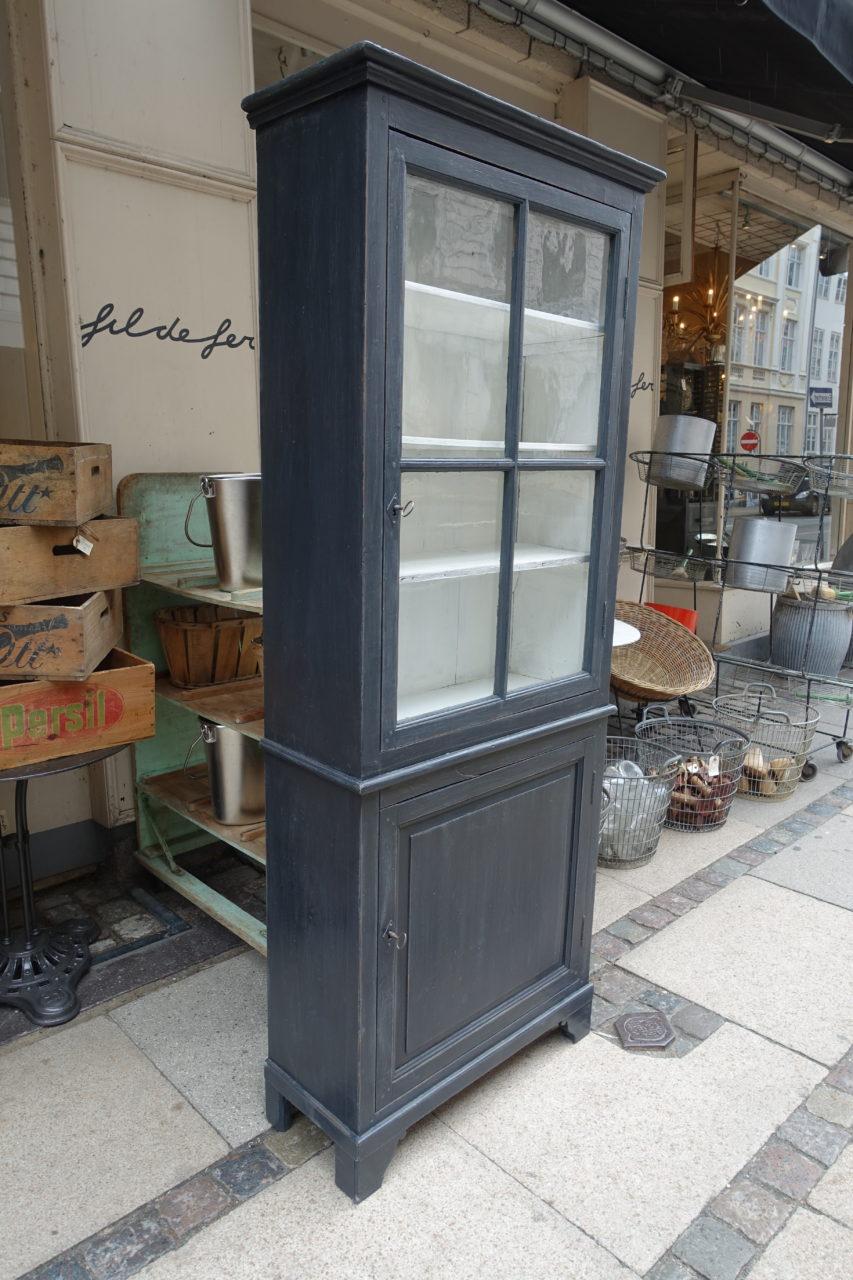 Charming little French grey or black painted vitrine cabinet, with a fine profile and detail. One paned glass door on the top half, and one smaller door in the lower part of the cabinet. Both halves have practical shelving and lock functions.

A