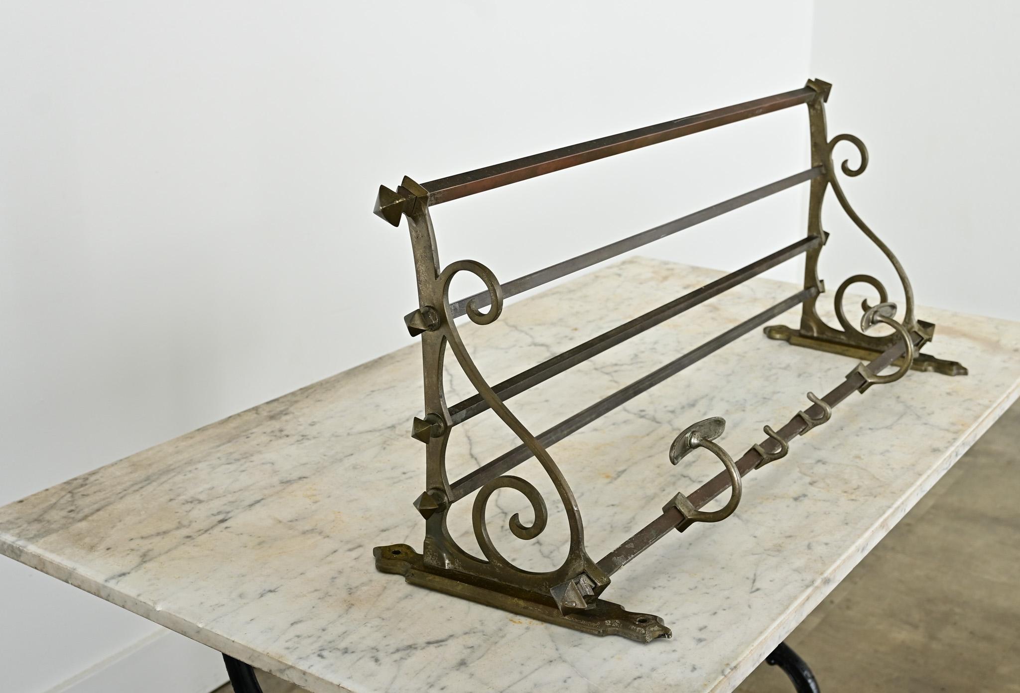 This French, vintage 20th century (circa 1920) train rack would be the perfect shelf for an entryway, mudroom, or even a kitchen. Patinated brass makes for attractive and durable construction of the frame that is accented with beautiful scrollwork