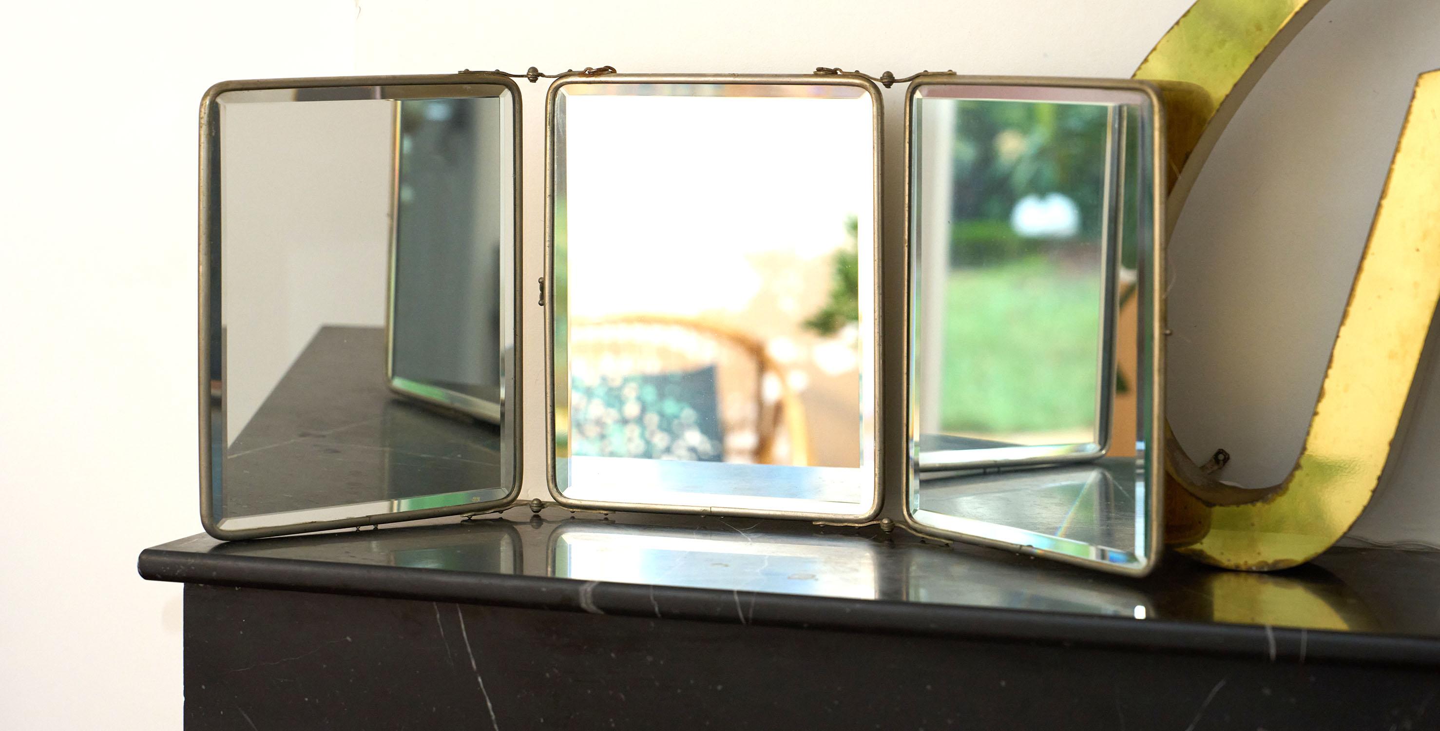 Miroir de barbier vintage, monté en triptyque. Elle est entourée d'un cadre en métal argenté et munie d'une chaîne murale. Les miroirs sont biseautés. Il date des années 1940-50 et a été fabriqué en France.

☛ ♥️ pour la taille de ce miroir, qui