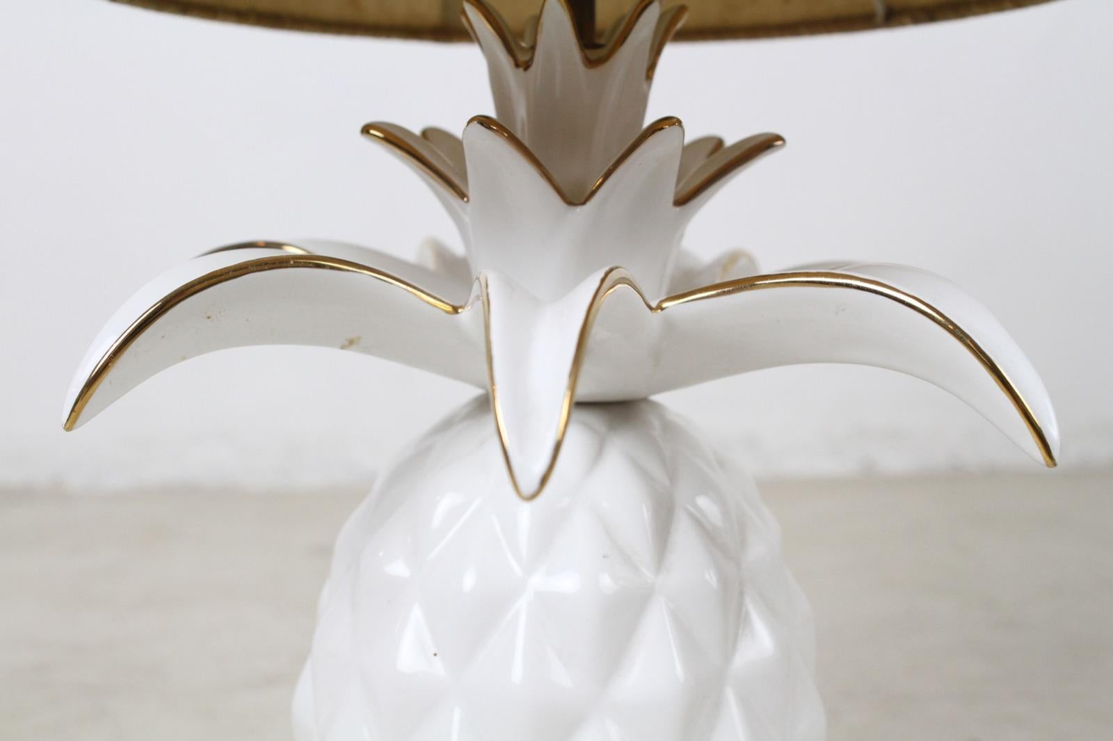 French white glazed ceramic pineapple lamp with the original shade. The golden lines on the rims of the leaves are gorgeous. It is working with an E27 bulb.
 