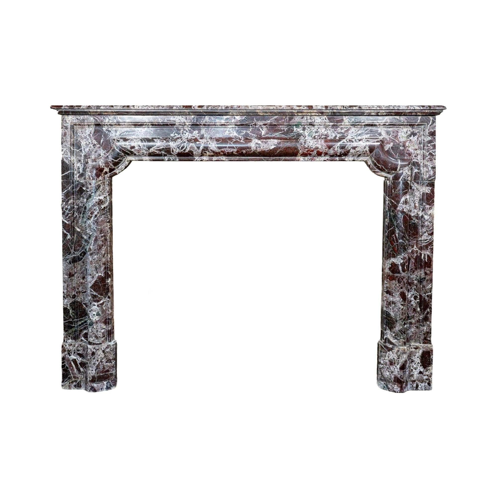 This French Violet Breccia Marble Mantel is an antique piece from the 1880s, crafted in the style of Louis XIII. Made out of stunning violet breccia marble, this mantel features elegant bolection design carvings. Features two bronze air vents for