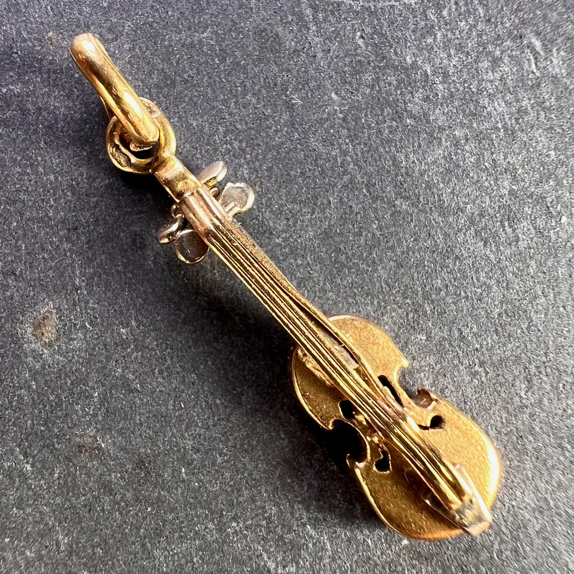An 18 karat (18K) yellow gold charm pendant designed as a violin with white gold details. Stamped with the eagle's head for French manufacture and 18 karat gold along with an unknown maker's mark.
 
Dimensions: 2.4 x 0.5 x 0.35 cm
Weight: 1.67