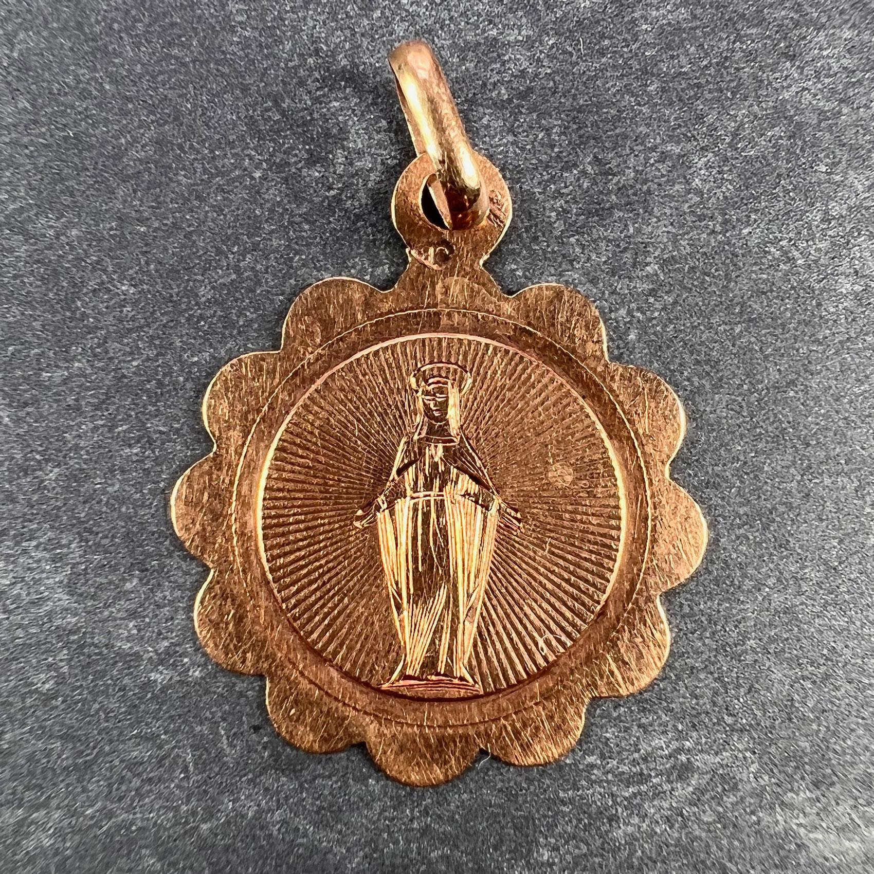A French 18 karat (18K) rose gold charm pendant designed as a medal depicting the Virgin Mary. Stamped with the horse’s head mark for 18 karat gold and French manufacture between 1838 and 1919, with an unknown maker's mark.  

Dimensions: 2.2 x 1.8