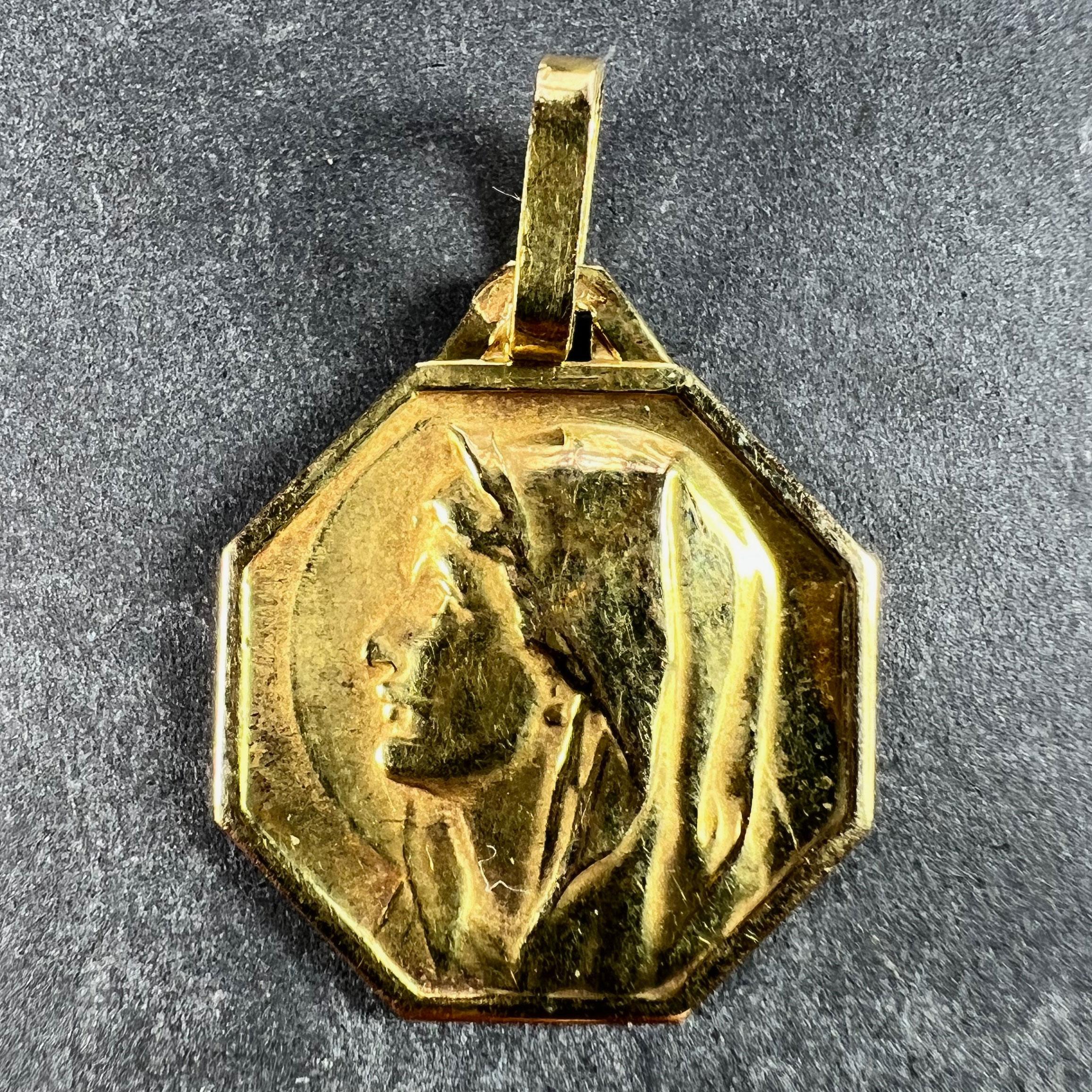 An 18 karat (18K) yellow gold charm pendant designed as an octagonal medal depicting the Virgin Mary in profile with a halo. Stamped with the eagle’s head for French manufacture and 18 karat gold, and an unknown maker’s mark.

Dimensions: 1.9 x 1.7
