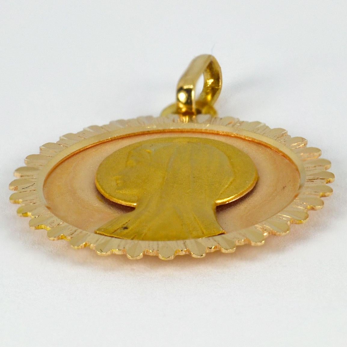 An 18 karat (18K) yellow gold pendant designed as a round medal depicting the Virgin Mary against a sunburst ground. Stamped with the eagle’s head for French manufacture and 18 karat gold, with unknown maker’s mark.

Dimensions: 2.6 x 2.3 x 0.2 cm