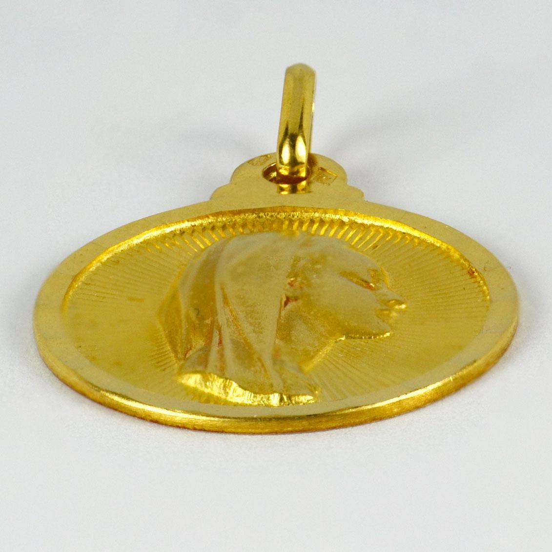 An 18 karat (18K) yellow gold pendant designed as a medal depicting the Virgin Mary within a sunburst. Stamped with the eagle’s head for French manufacture and 18 karat gold, with maker’s mark for Sonne of Lyon.

Dimensions: 2.5 x 2.1 x 0.2 cm (not