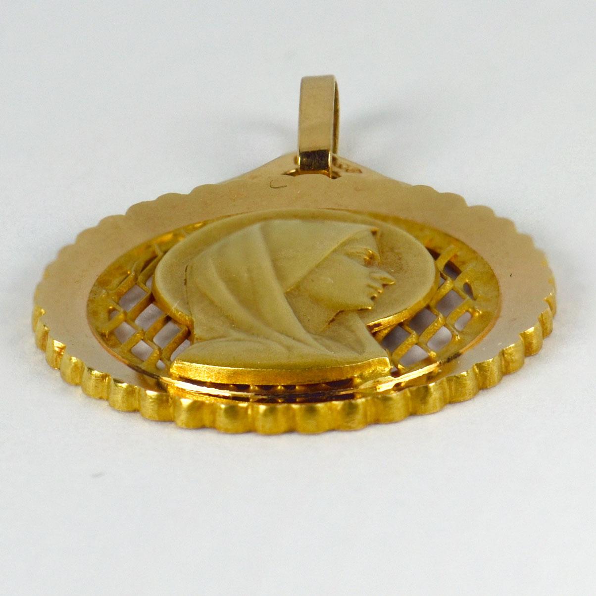 An 18 karat (18K) yellow gold pendant designed as a medal depicting the Virgin Mary against a pierced fretwork ground. Stamped with the eagle’s head for French manufacture and 18 karat gold, with maker’s mark for Grard of Nice.

Dimensions: 2.2 x