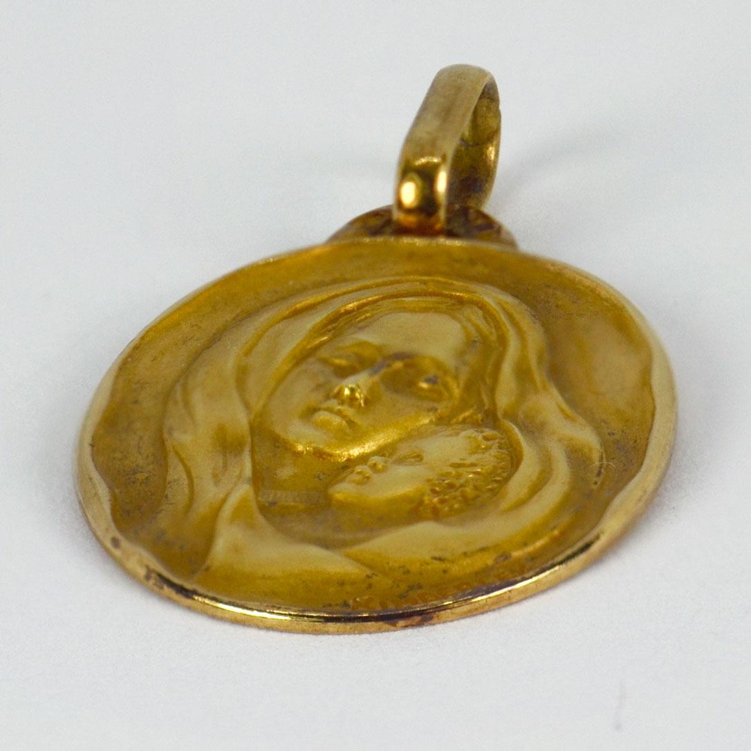 An 18 karat (18K) yellow gold pendant designed as an oval medal depicting the Virgin Mary. Signed Kimberley. Stamped with the eagle’s head for French manufacture and 18 karat gold, with unknown maker’s mark.

Dimensions: 2.4 x 1.6 x 0.15 cm (not