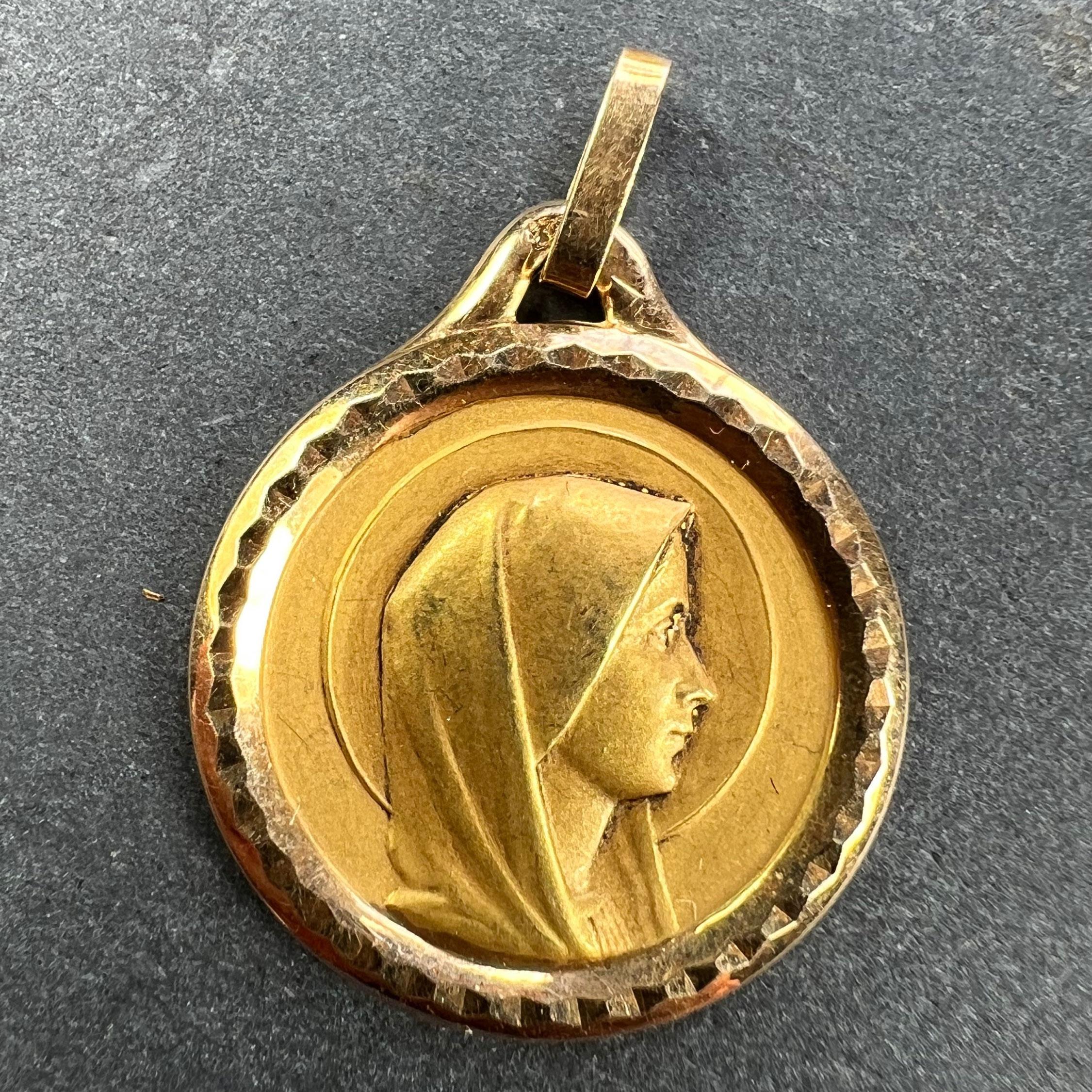 A French 18 karat (18K) yellow gold pendant designed as a round medal depicting the Virgin Mary in profile with a halo. Stamped with the eagle’s head for French manufacture and 18 karat gold with an unidentified maker's mark.

Dimensions: 2.1 x 1.8