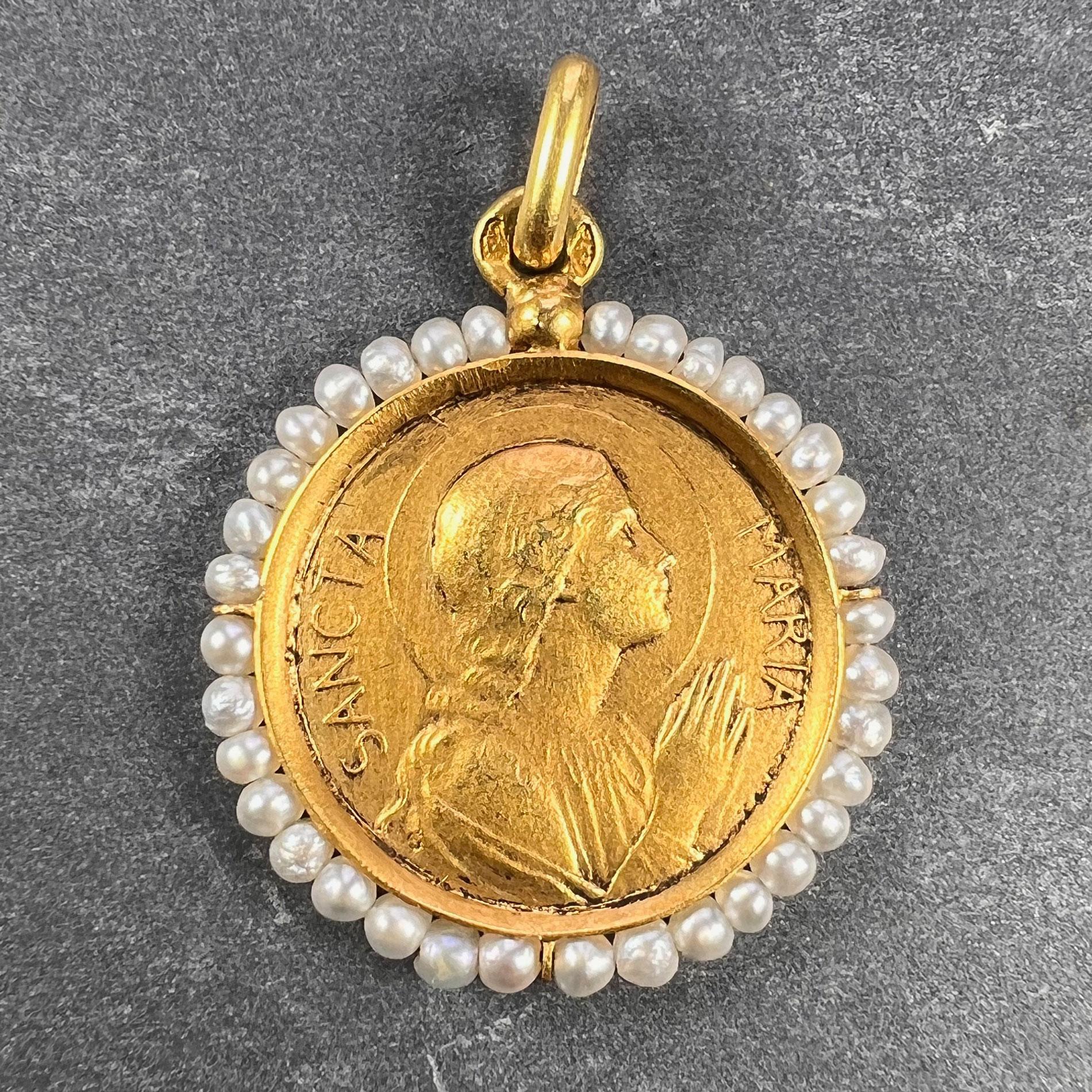 Ein französischer Anhänger aus 18 Karat (18K) Gelbgold in Form einer Medaille, die die Jungfrau Maria mit der Aufschrift Sancta Maria darstellt, umgeben von einer Saatperlenbordüre mit 34 natürlichen Perlen. Gestempelt mit der Adlermarke für 18