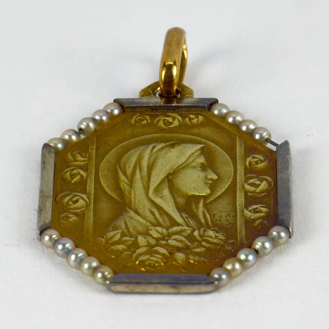 An 18 karat (18K) yellow gold pendant designed as a medal depicting the Virgin Mary with a surround of 19 natural seed pearls. Engraved to the reverse with a monogram of FC and the date ‘31 Mai 1934’.  Signed E.A. and J.S., stamped with the eagle’s