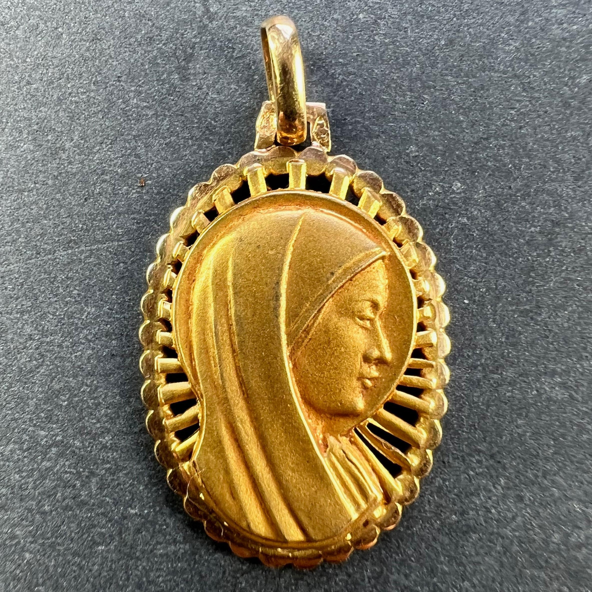 A French 18 karat (18K) yellow gold pendant designed as an oval medal depicting the Virgin Mary within a pierced sunburst frame. Stamped with the eagle’s head for French manufacture and 18 karat gold, with an unknown maker’s mark.

Dimensions: 2.4 x