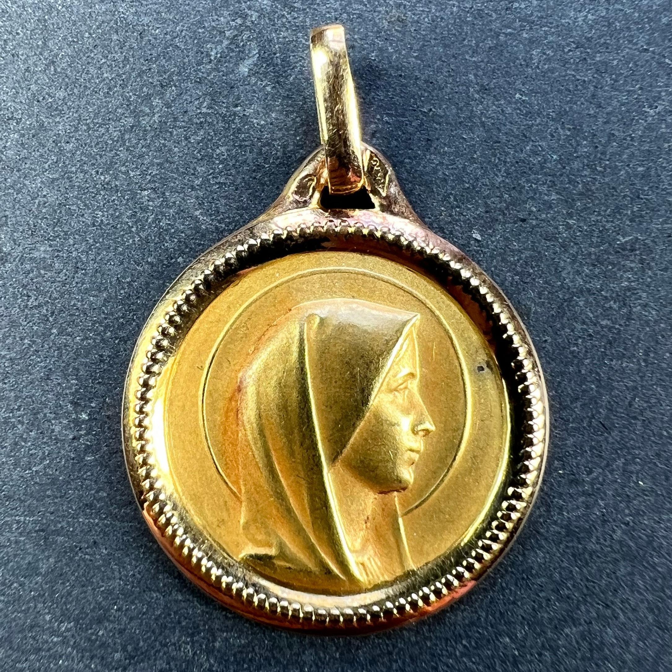Ein französischer Anhänger aus 18 Karat (18K) Gelbgold in Form einer runden Medaille, die die Jungfrau Maria in einem Heiligenschein und einem Perlenrahmen darstellt. Gestempelt mit dem Adlerkopf für französische Herstellung und 18 Karat Gold, mit