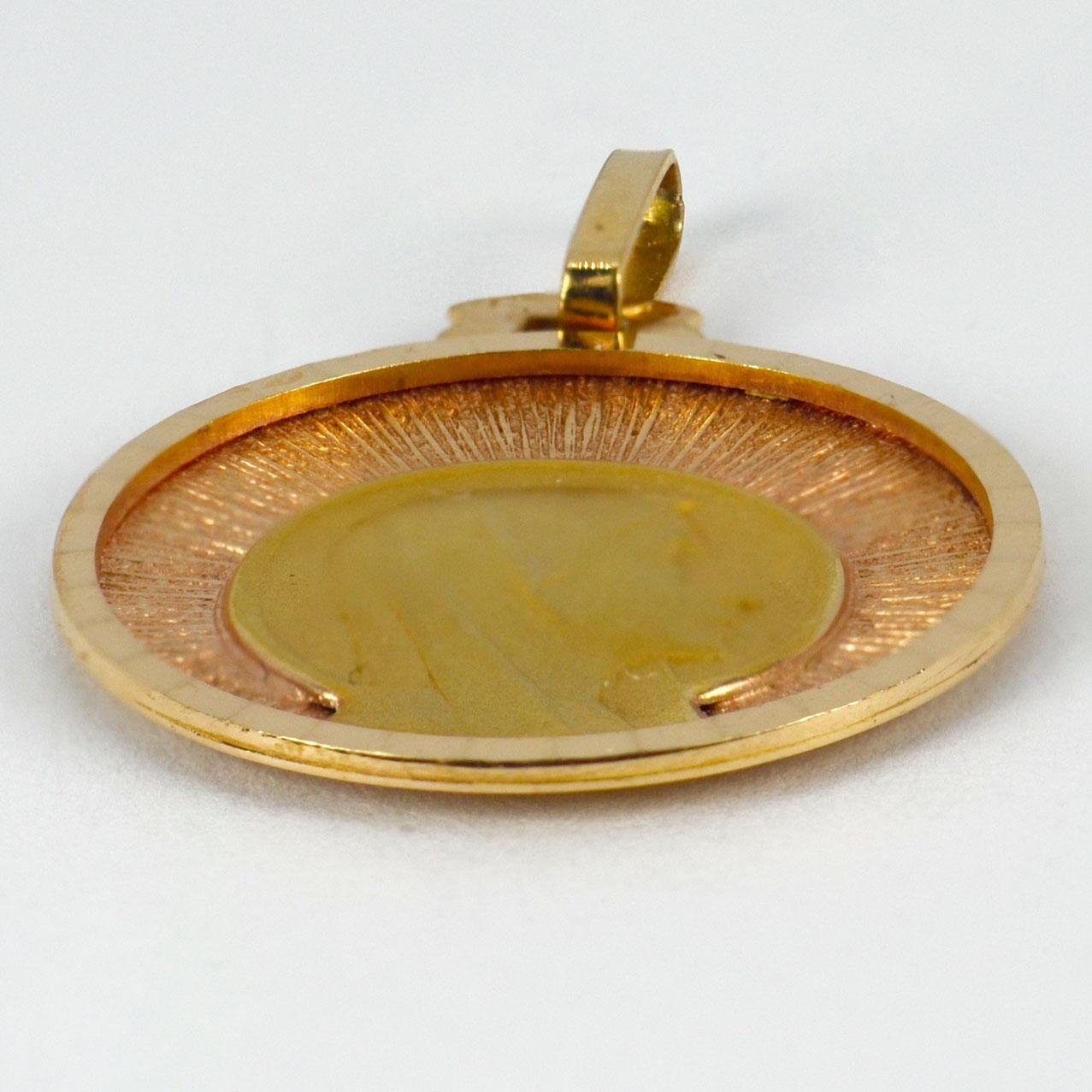 An 18 karat (18K) yellow and rose gold pendant designed as a round medal depicting the Virgin Mary against a sunburst ground. Stamped with the eagle’s head for French manufacture and 18 karat gold, with unknown maker’s mark.

Dimensions: 2.3 x 2 x