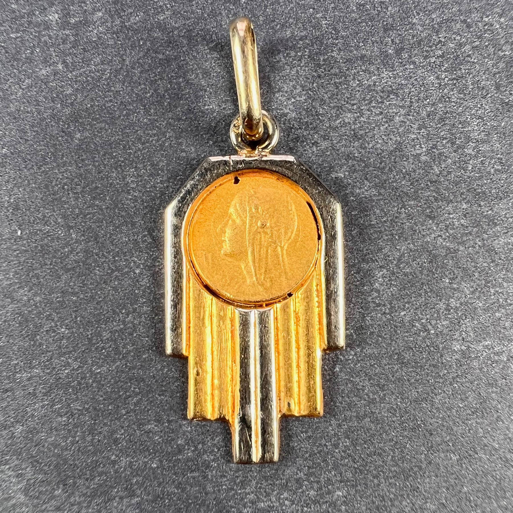 A French 18 karat (18K) yellow and white gold charm pendant designed as an Art Deco geometric pendant set with a circular medal depicting the Virgin Mary. Stamped with the eagle mark for 18 karat gold and French manufacture.

Dimensions: 2.2 x 1.1 x