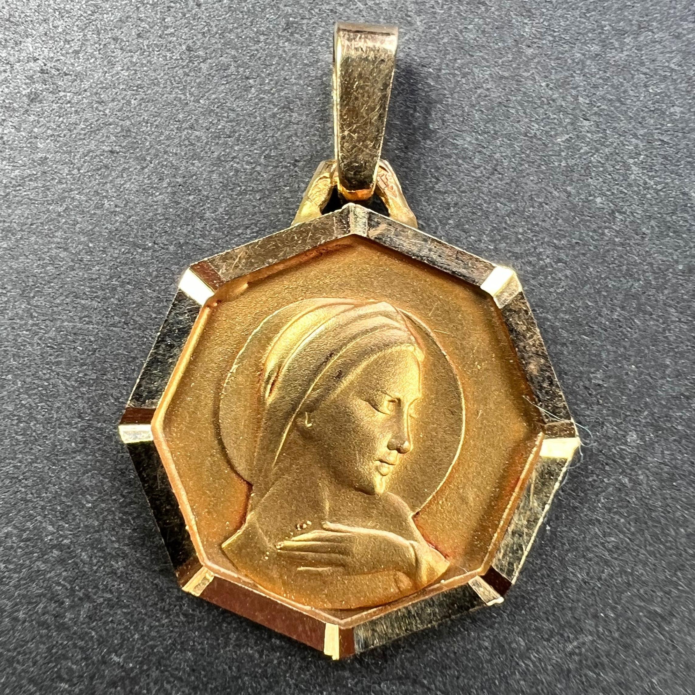 Pendentif de charme français en or jaune 18 carats (18K) conçu comme une médaille octogonale représentant la Vierge Marie. Estampillé avec la tête d'aigle pour la fabrication française et l'or 18 carats, et une marque de fabricant