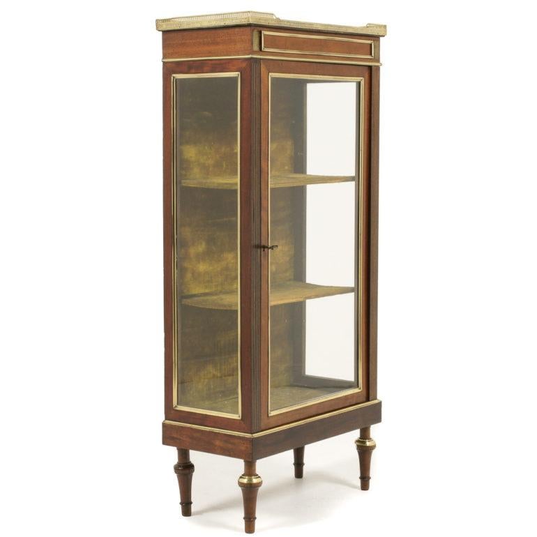 A lovely quality, smaller, Napoleon III vitrine with polished brass trim and original marble top, with a pierced brass gallery surround, circa 1875.

    